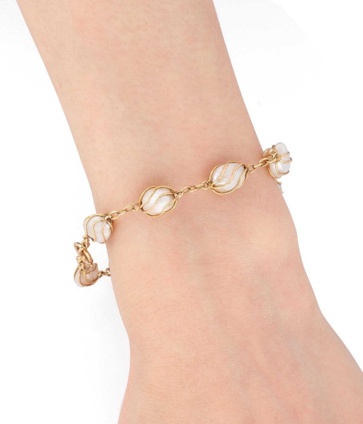 Brazalete antiguo en oro de 18 quilates (750 millones) de principios del siglo XX, compuesto por 10 perlas de cultura barroca retenidas en filetes de oro.

Poids total du bijou : 9,37 g environ.
Longueur 22 cm.
Poinçon tête d'aigle. 
