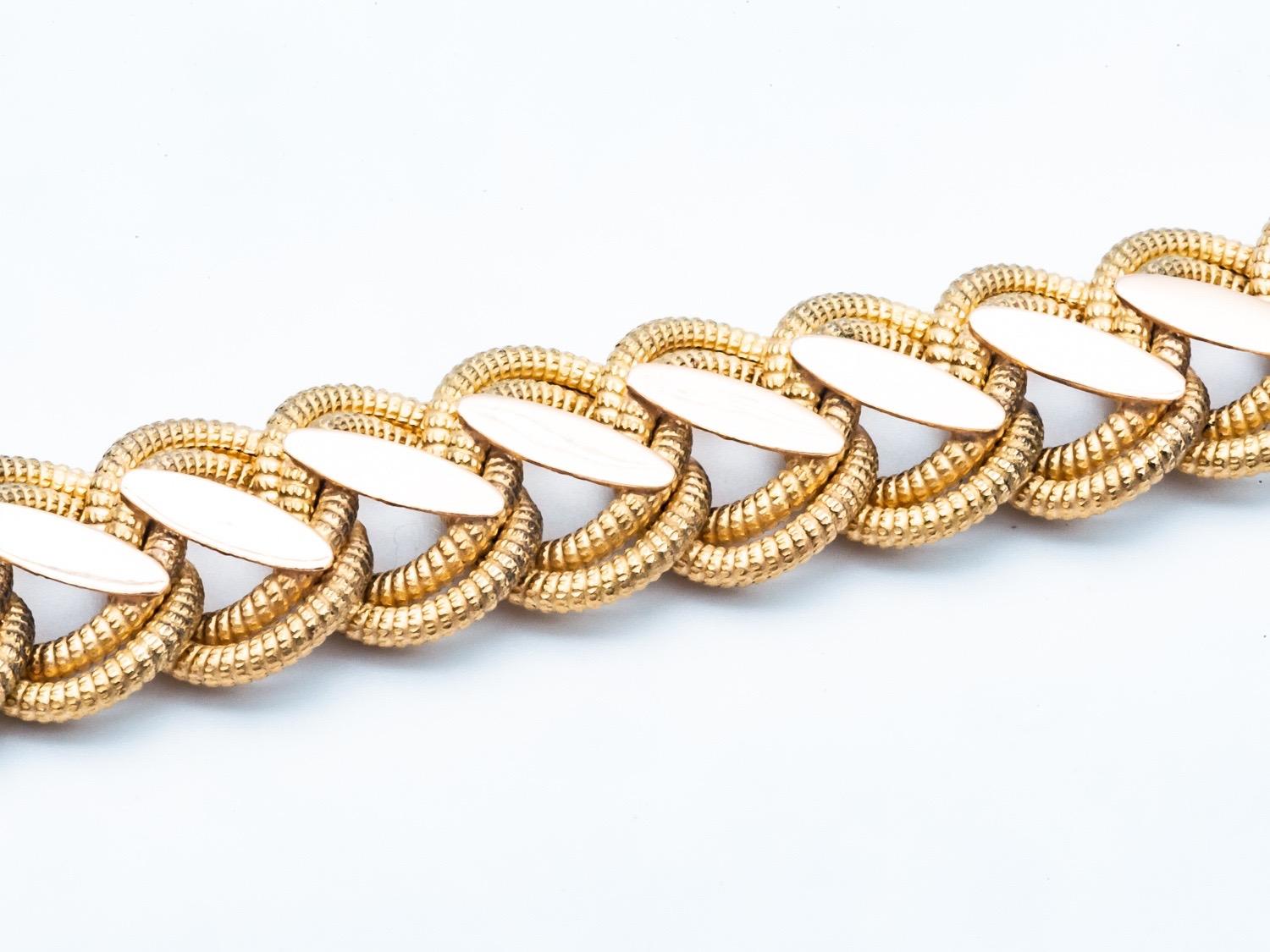 This magnificent 18K yellow gold bracelet is a true period jewel, embodying the timeless elegance of the 1960s. Crafted with care and expertise, this bracelet features a unique combination of brushed and polished mesh, giving it a refined yet modern