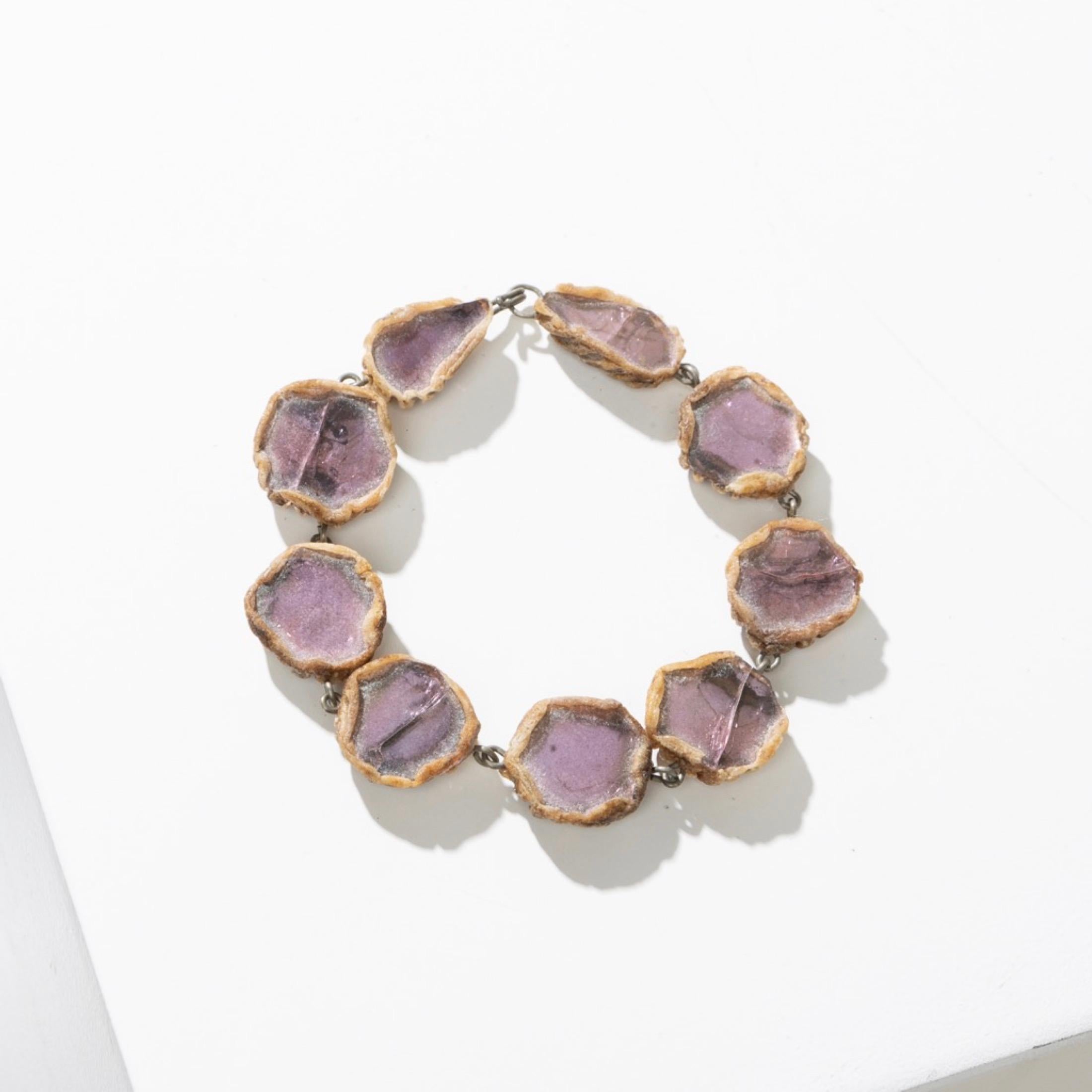 This beige Talosel bracelet has been meticulously hand-sculpted by scarification to create an organic shape reminiscent of the emblematic creations of Line Vautrin.
Each link, there are seven in total, is adorned with purple mirrors subtly embedded