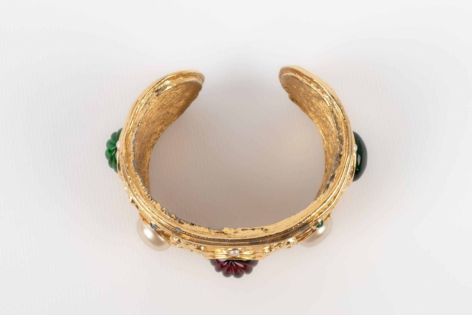 Dior - Golden metal bracelet ornamented with pearly and glass paste cabochons.

Additional information:
Condition: Very good condition
Dimensions: Length: 14.5 cm - Opening: 2.2 cm

Seller Reference: BRA156