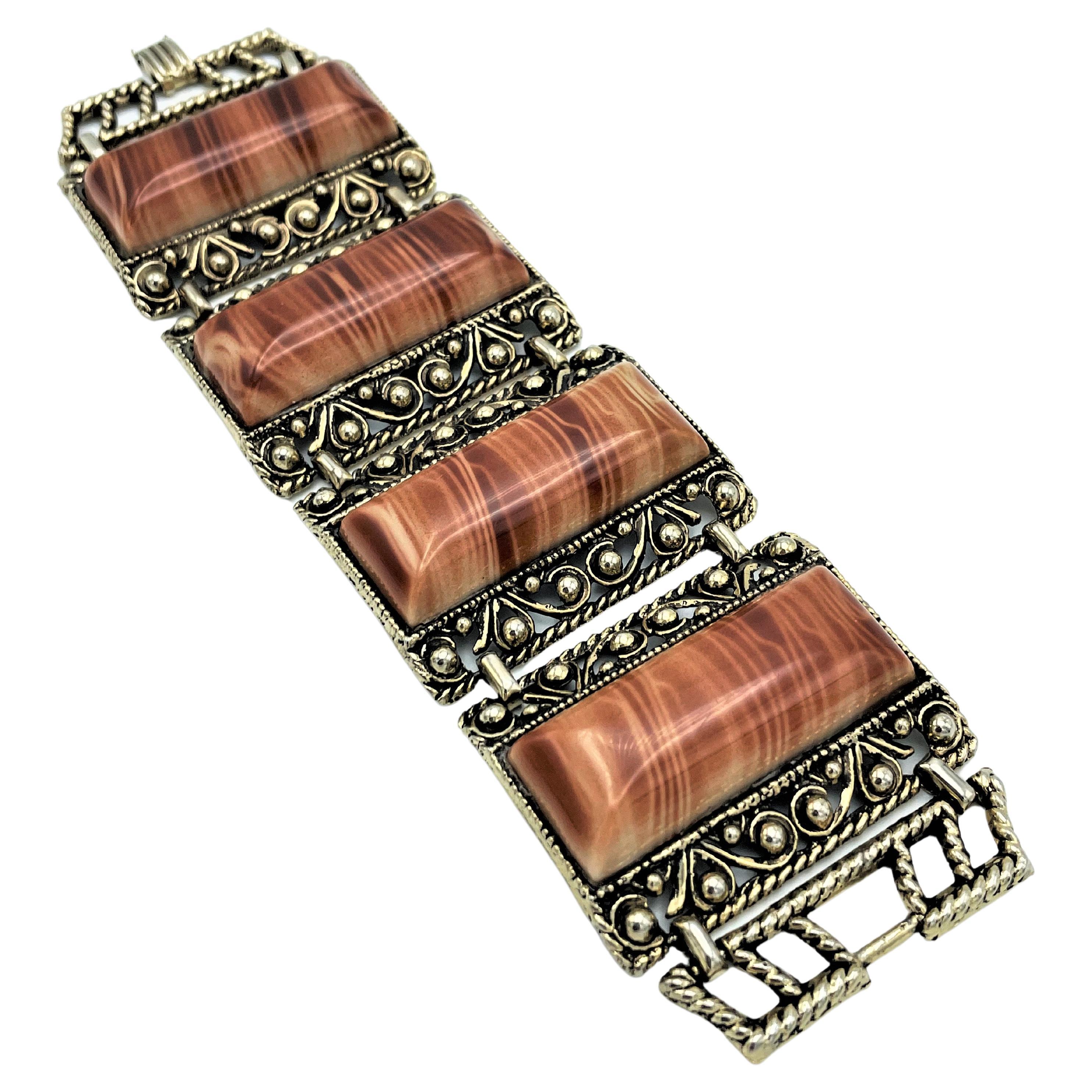 About
Flexible bracelet consisting of 4 marbled plastic parts, finely set in fine metal work; USA 1980s
Measurement
Length  19 cm 
Width     5 cm 
Deep      1 cm 
Features
- 4 moving parts, each 5 cm x 3.8 cm
- Material such as Bakelite
- A