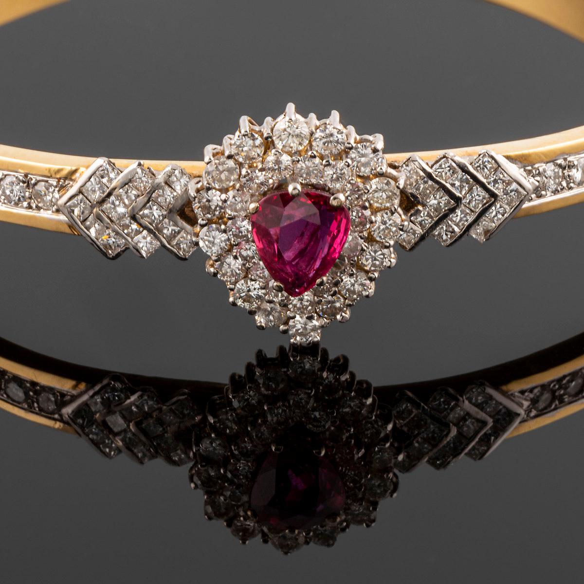 Cocktail clamper bracelet  in yellow gold and white gold, with teardrop-shaped ruby ​​and diamonds.
total weight 6.23gr.

The piece was part of a set, with a necklace with a pendant, and ring all with same design in gold, ruby and diamonds. Contact