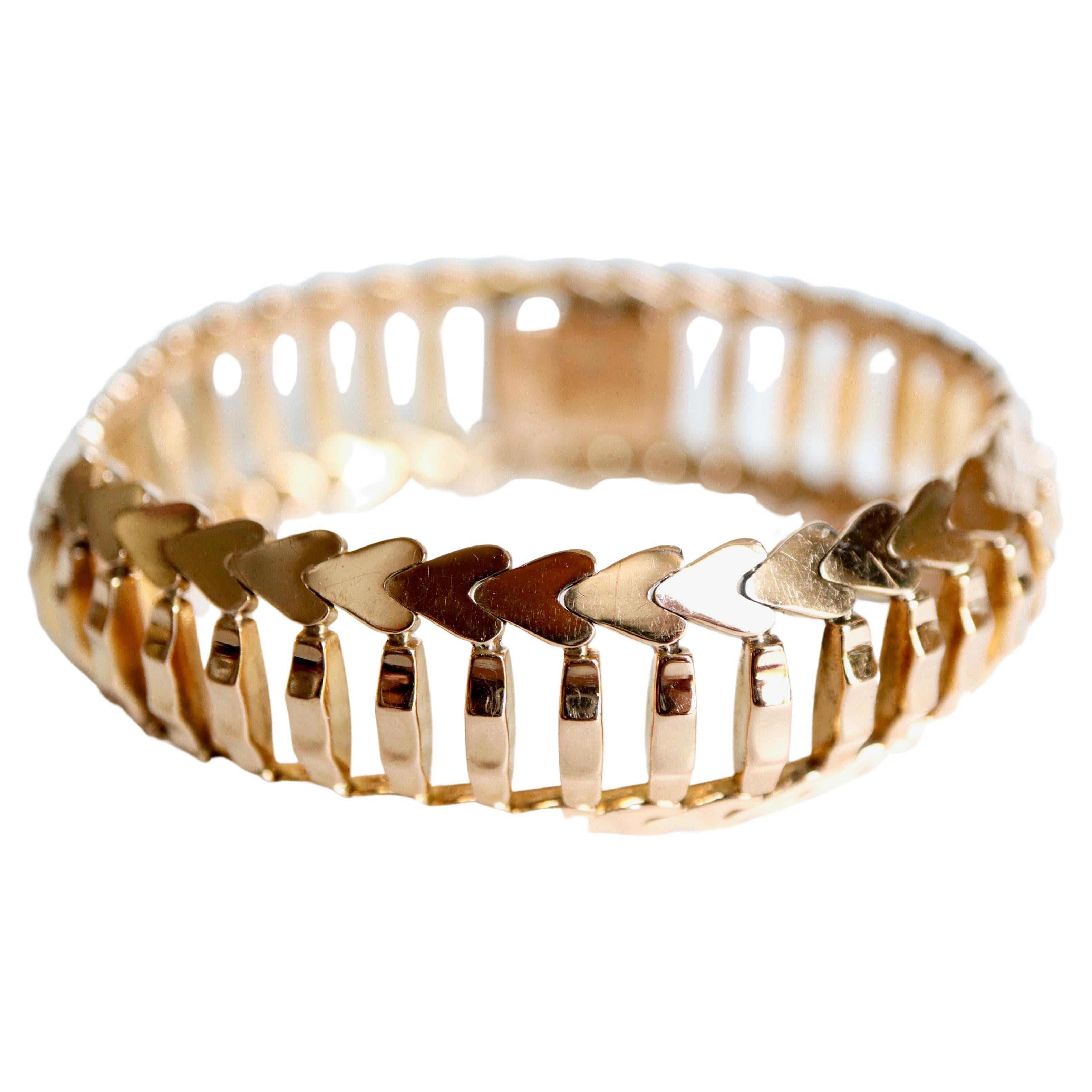 Armband um 1960 aus 18 Kt Gelbgold mit gegliederten Gliedern in Form von Stöcken, umgeben von Herzen.
Länge: 20cm Breite: 2cm
Nettogewicht: 53,8 g 
