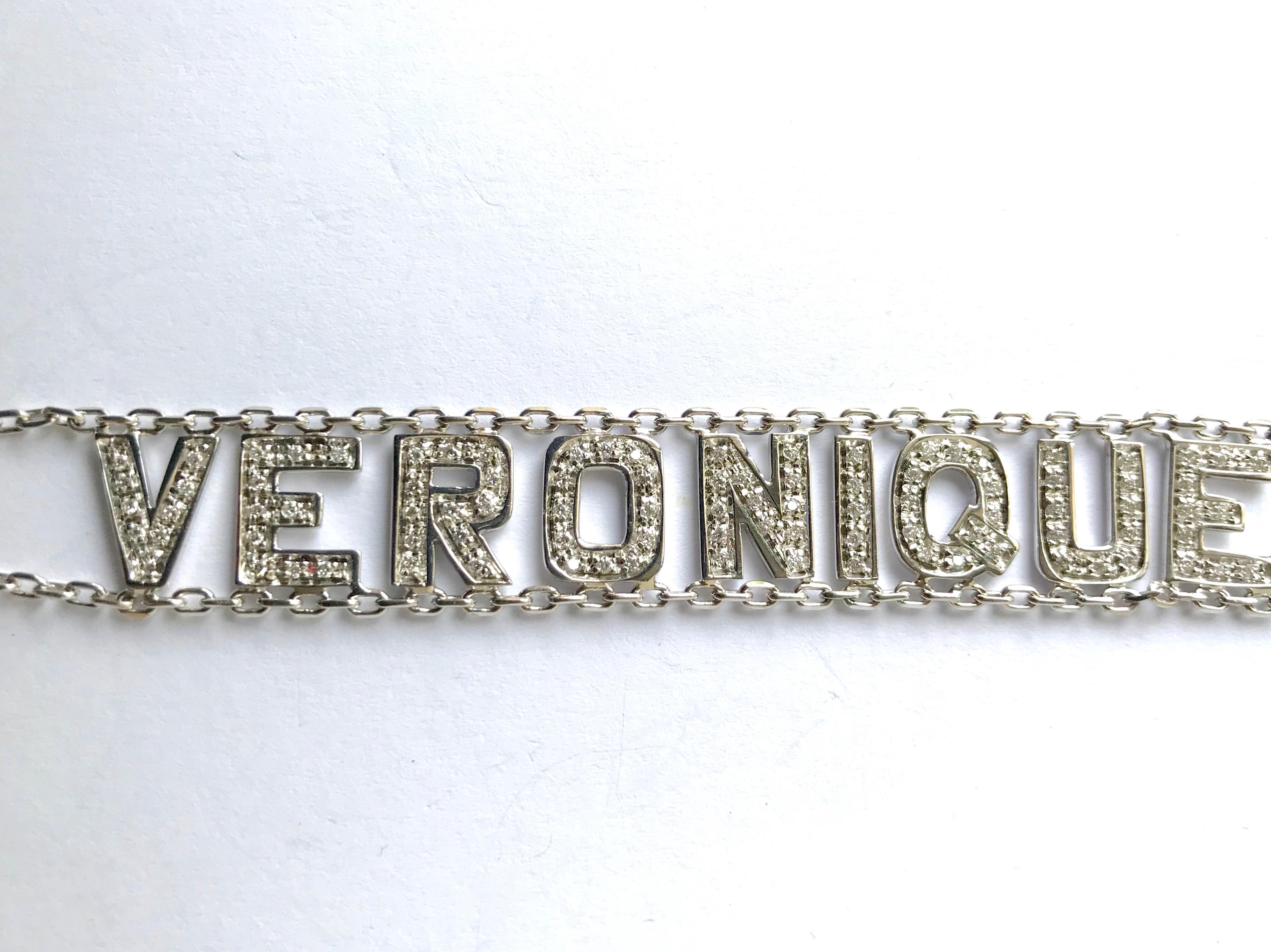 Bracelet in 18 Kt (750 mil) white gold and diamonds with the first name Veronique. 
Two 18 kt white gold chains hold the first name VERONIQUE, the letters of which are entirely set with diamonds. This bracelet is numbered and is in very good