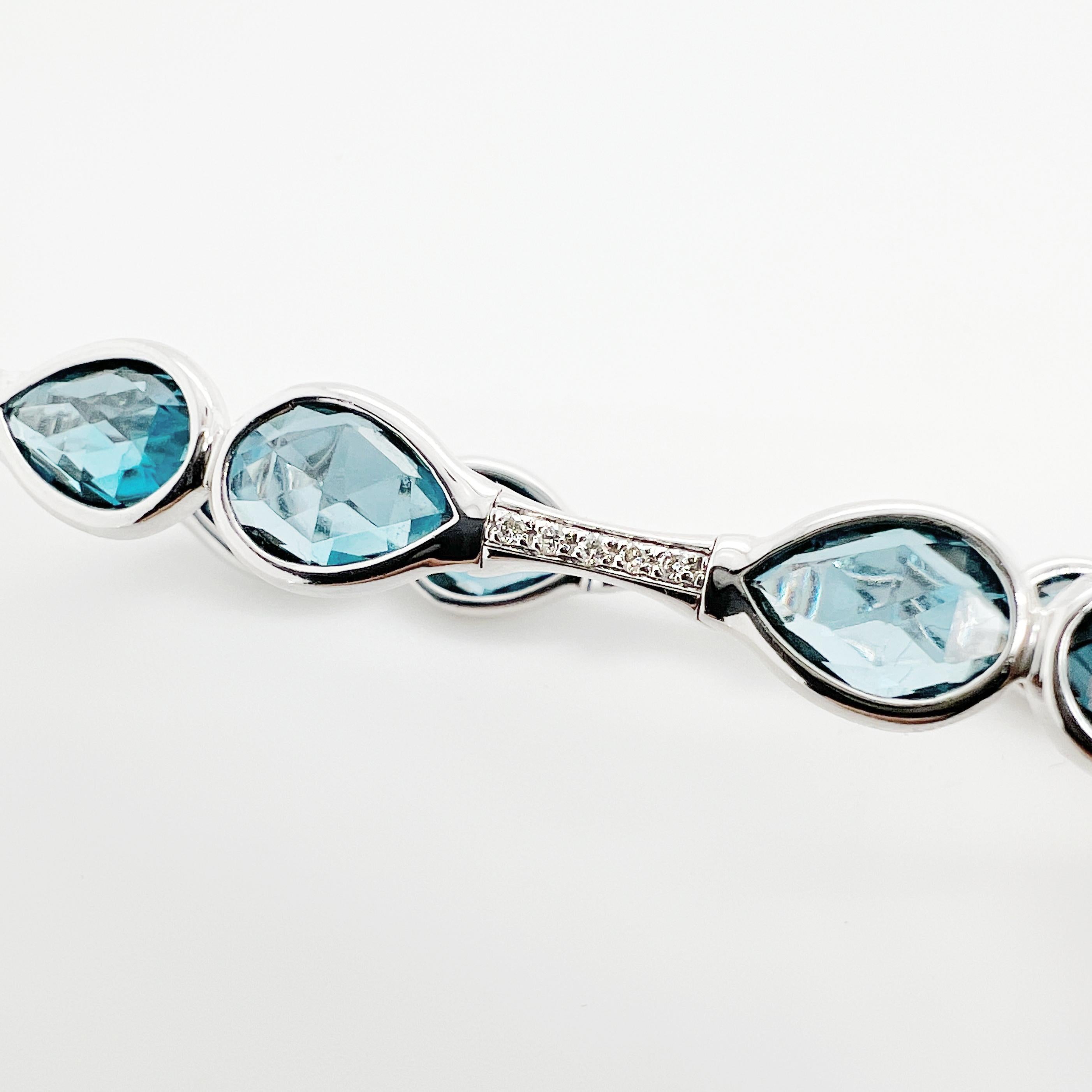 This bracelet is a  stunning combination of diamonds and blue topaz. The diamonds are expertly set within the intricate golden structure, providing a dazzling sparkle with every movement of the bracelet. The blue topaz gemstones add a vibrant pop of
