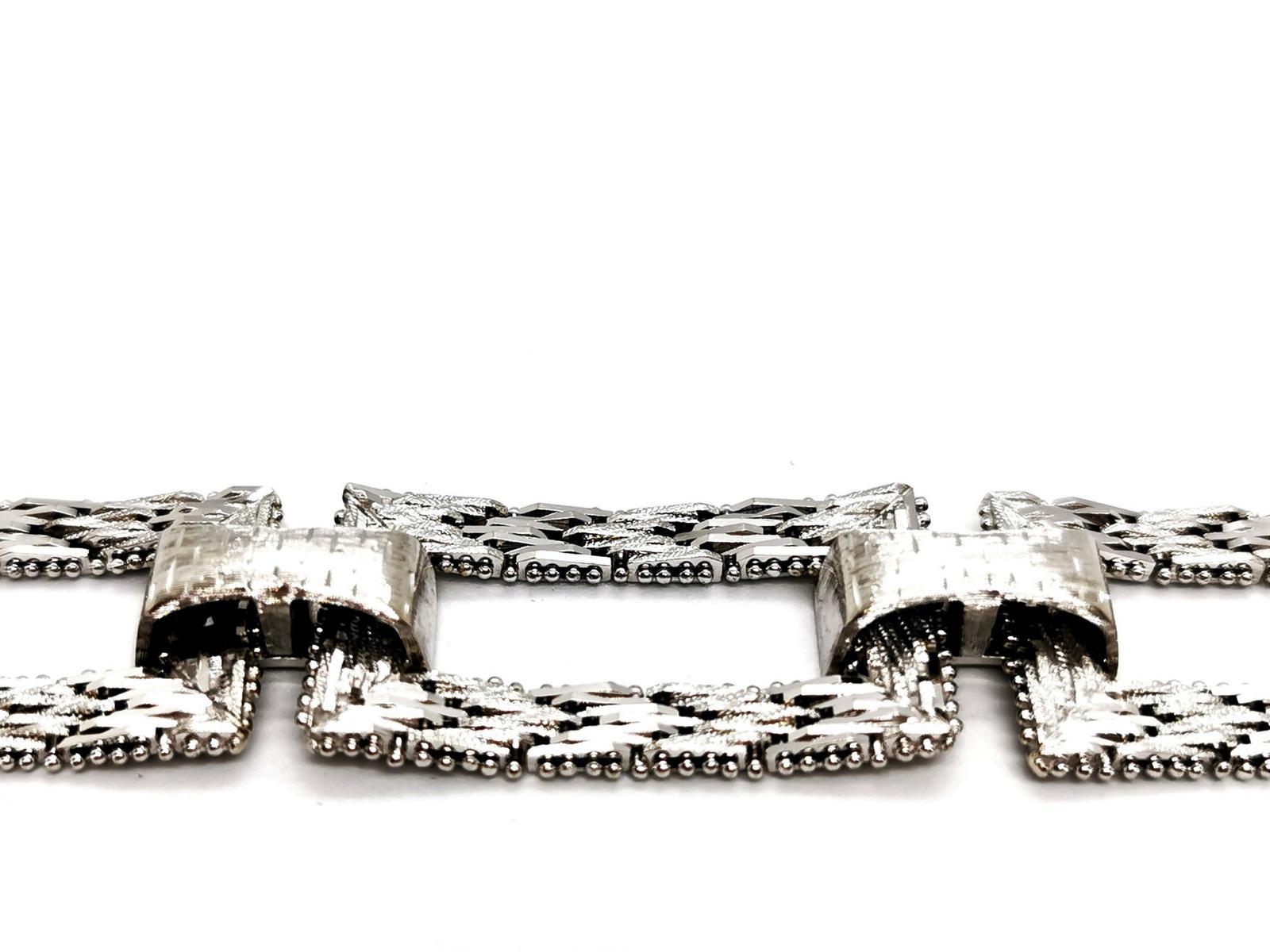 Bracelet art deco. white gold 750 mils (18K). composed of five rectangular flexible links. worked in matt or shiny. length: 19 cm. width: 1.85 cm. rectangular patterns dimensions: 3.4 cm x 1.85 cm. with eight safety clasp. total weight: 57.30 g.