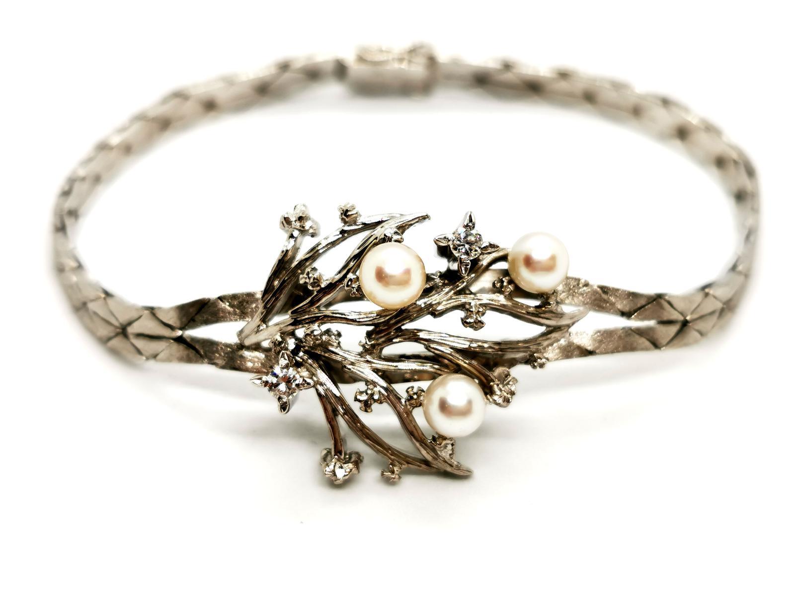 Vintage bracelet. 750 thousandths white gold (18K). center in white gold foliage pattern set with two brilliant cut diamonds of approximately 0.055 ct each. total weight diamonds: 0.11 ct approximately topped 3 cultured pearls with a diameter of