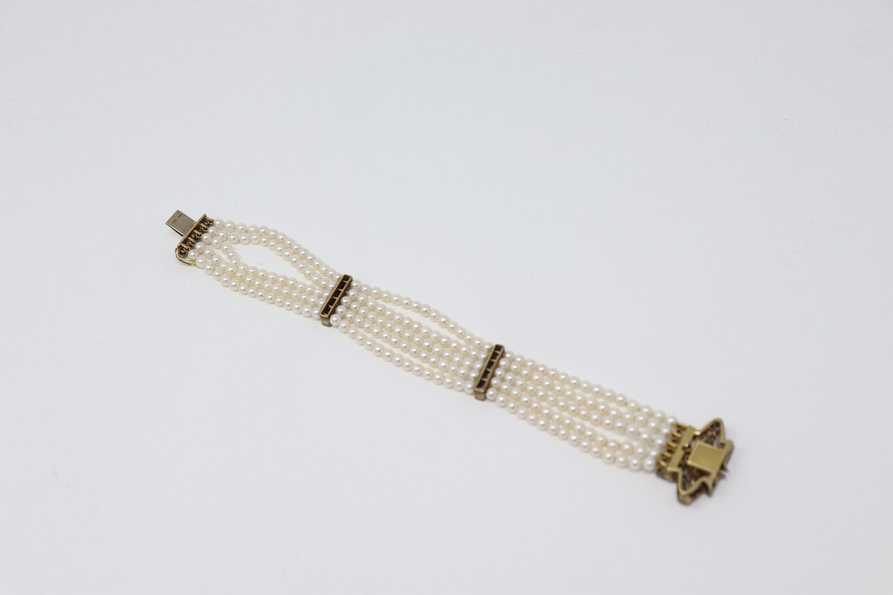 Refined bracelet with five strands of pearls in 18 Karat gold and 800 silver. The pearls are alternated medallion with a decoration of great refinement. The closure is retractable. High quality Italian goldsmith circa 1980s. Very refined and elegant
