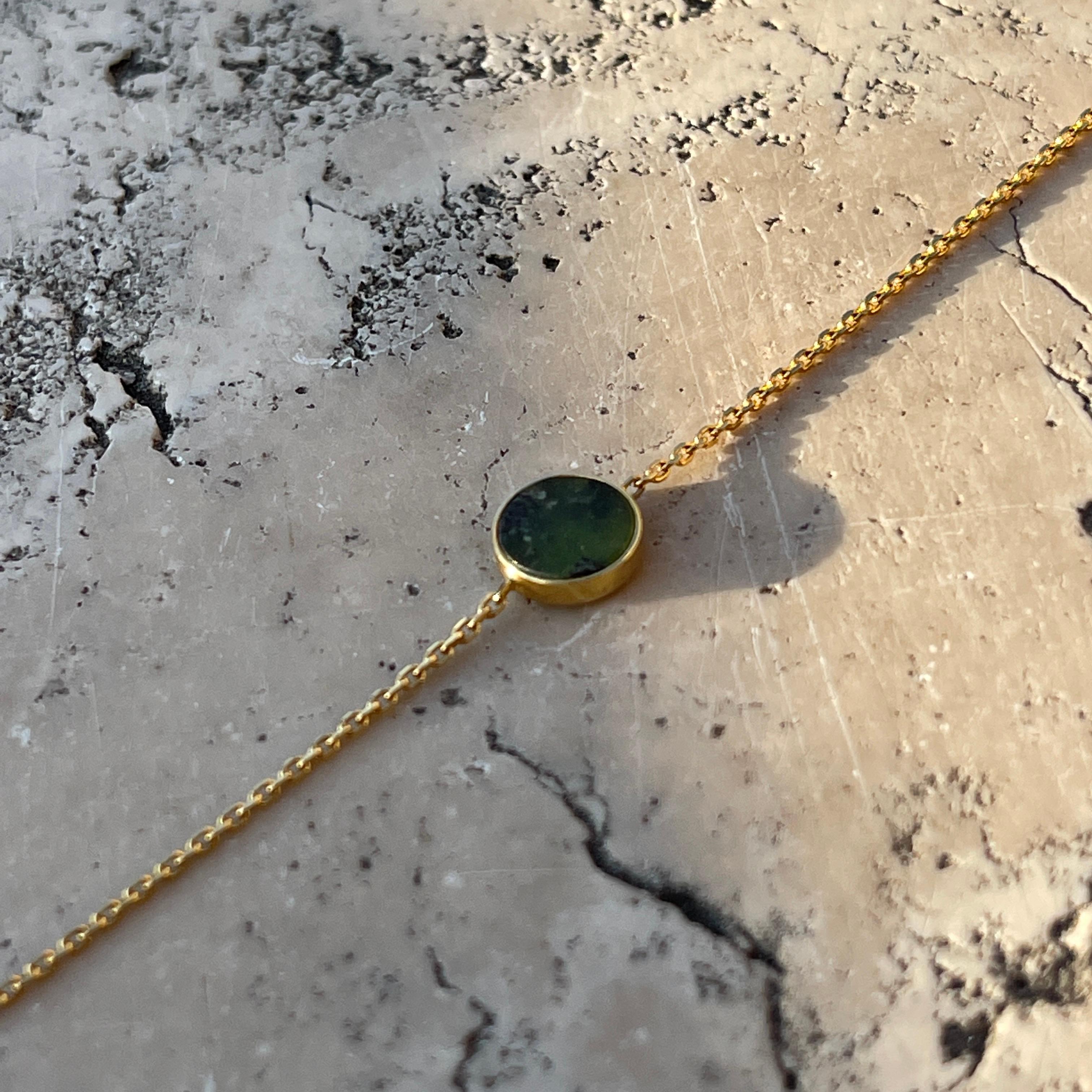 This bracelet with a dark green stone on a delicate gold chain will be a beautiful adornment for your wrist. Its minimalist design means you can wear it with practically any outfit. It will be perfect for both elegant outings and meetings with