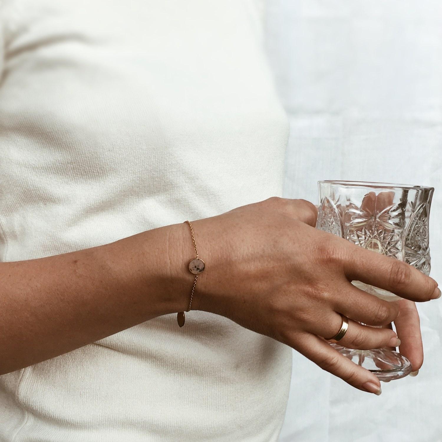 Dieses Armband mit einem rosagrauen Stein an einer zarten Goldkette ist ein schöner Schmuck für Ihr Handgelenk. Sein minimalistisches Design ermöglicht es Ihnen, ihn zu praktisch jedem Outfit zu tragen. Er eignet sich sowohl für elegante Ausflüge