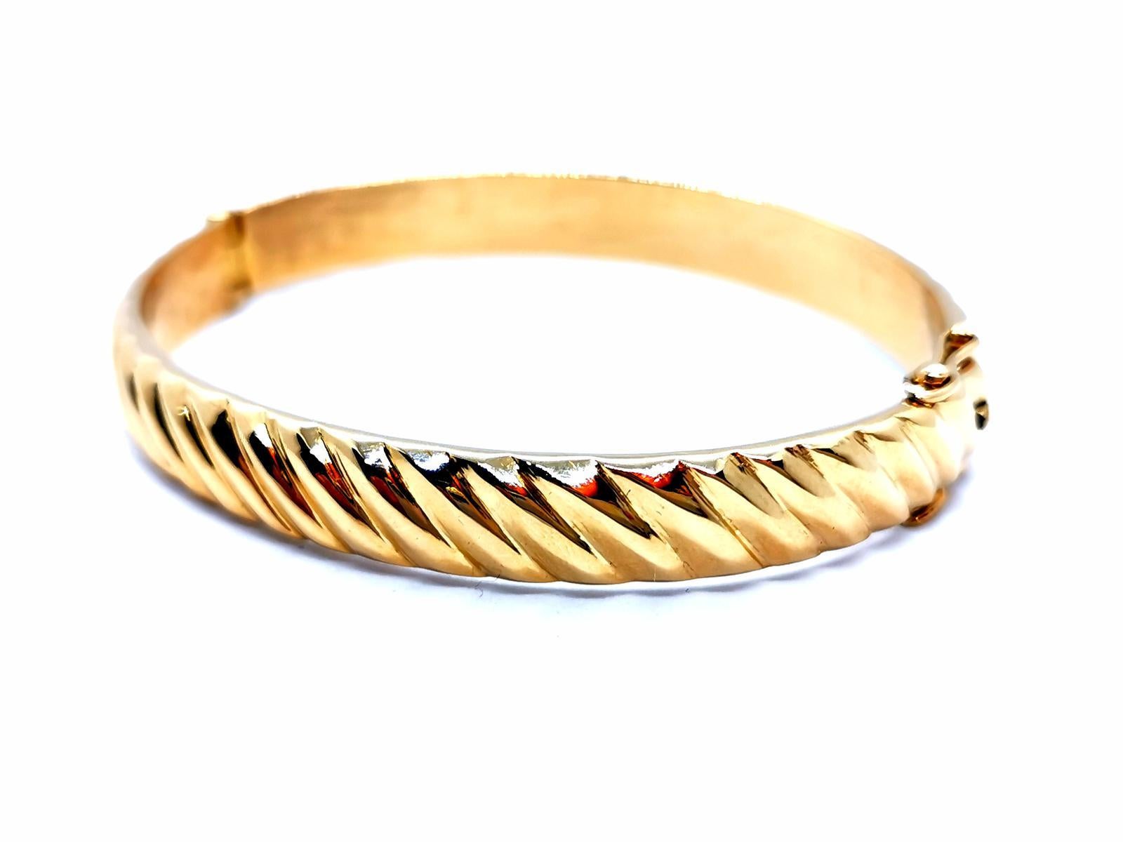 Bangle. gold yellow 750 mils (18 carats). ring opening. oval shape. size: 18 cm. inside diameter: 5.9 cm x 4.8 cm. width: 0.85 cm. thickness: 0.28 cm clasp with two eight safety. total weight: 51.81 g. punch eagle's head. excellent condition
