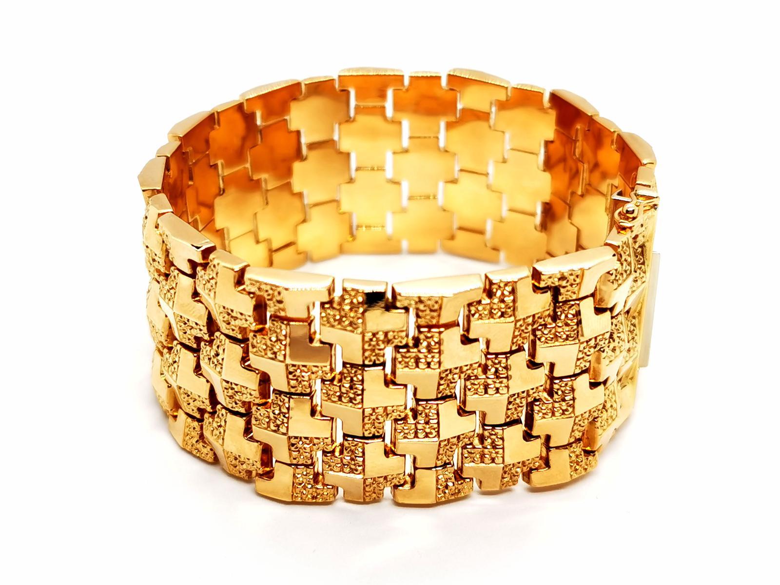 Cuff 750 thousandths yellow gold (18K). flexible mesh Geometric. smooth yellow gold and embossed. length: 19.5 cm. width: 3.08 cm. clasp tab with two safety eight tw : 67.89 g. owl punch. excellent condition
