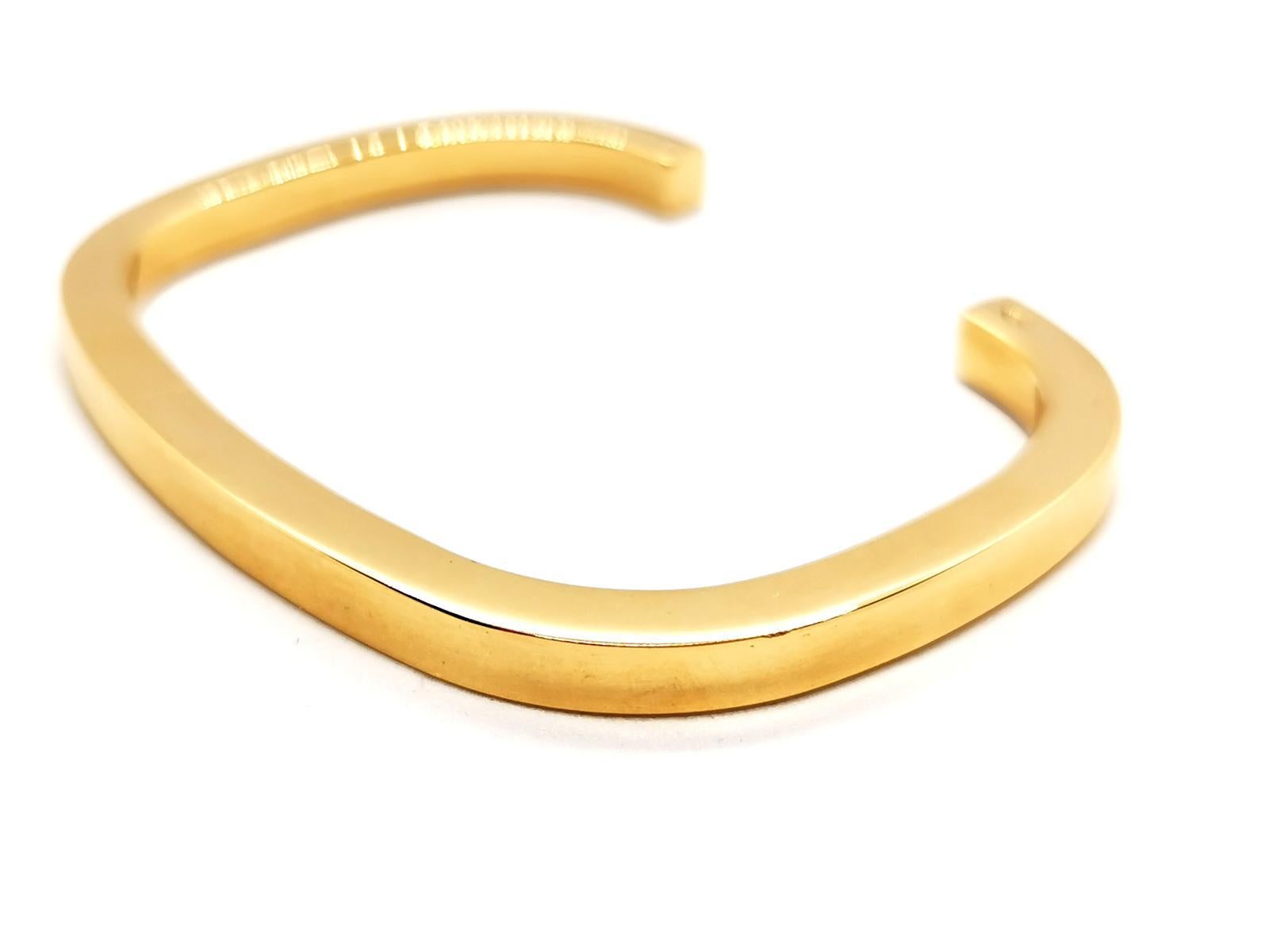 Bracelet open ring. golden yellow 750 mils (18 carats). solid. rectangular. inner diameter: 5.6 cm x 4.4 cm. height: 17 cm. width: 0.47 cm. total weight: 49.07 g. punch eagle's head. excellent condition.
