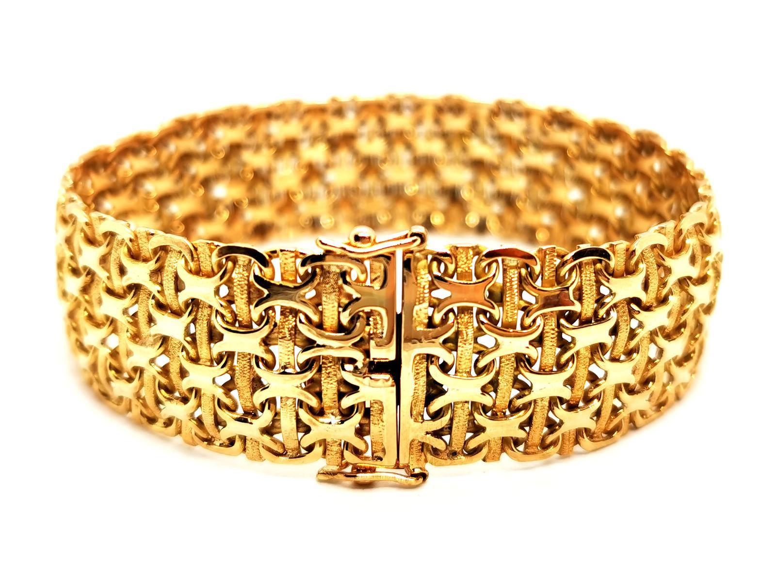 Cuff bracelet. in 750 thousandths (18 carat) yellow gold. cross pattern. in smooth gold and brushed gold. width: 1.80 cm. length: 19.5 cm. total weight: 49.47 g. clasp tongue. double safety eight. rhinoceros hallmark. excellent condition.
