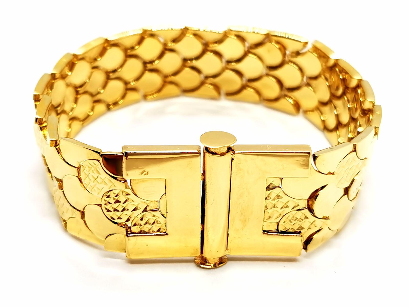 Cuff bracelet. in yellow gold 750 thousandths (18 carats). scale pattern. semi-articulated. length: 19 cm. width: 1.78 cm. total weight: 33.79g. Owl hallmark. excellent condition.
