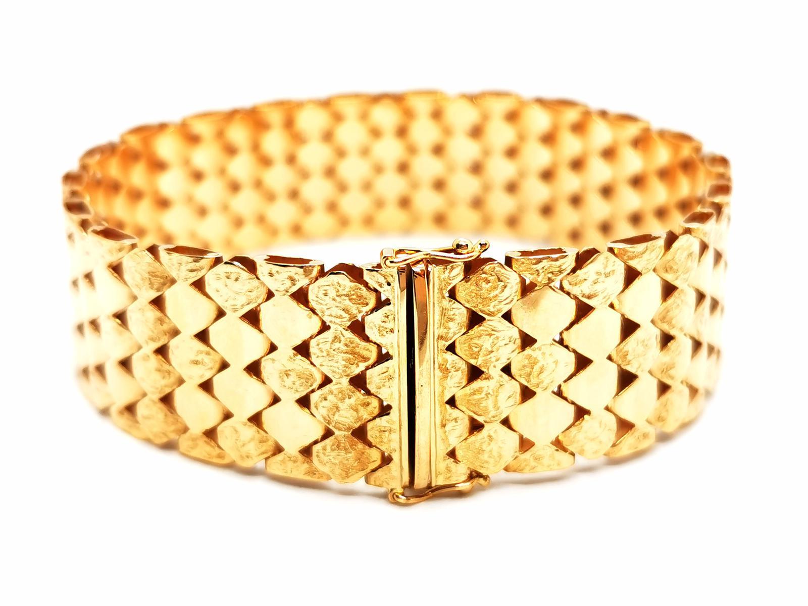 Cuff bracelet. in yellow gold 750 thousandths (18 carats). soft mesh. smooth mesh alternation and hammered mesh. length: 19 cm. width: 1.78 cm. clasp with two safety eights. total weight: 37.80 g. eagle head hallmark. excellent condition

