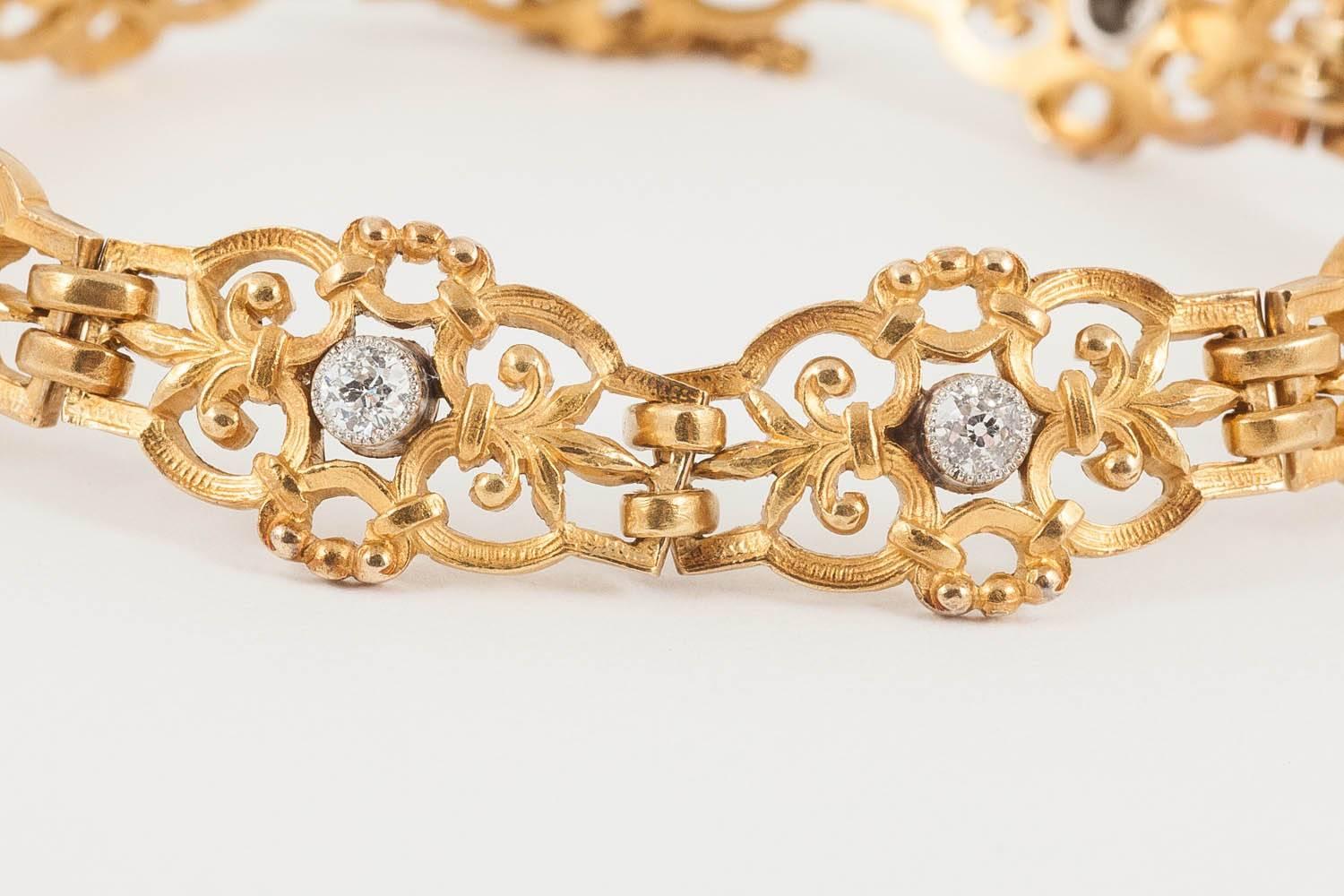 A heavy quality,18ct yellow gold bracelet of openwork,fleur de lys panels,each with a platinum set brilliant cut diamond centre,in perfect condition ,French marked c,1900