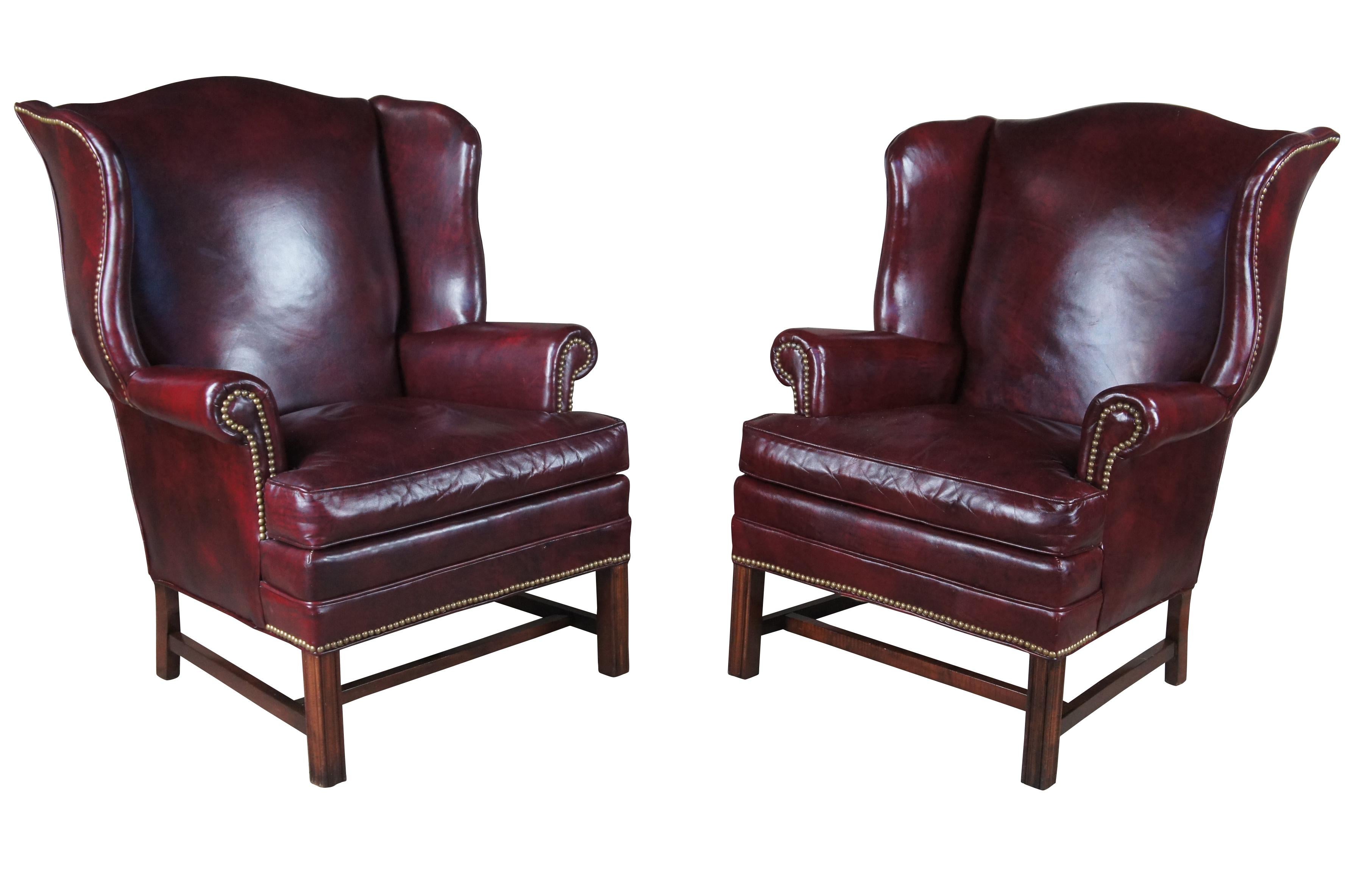 Vintage Bracewell Furniture Co leather wingback armchairs featuring serpentine Chippendale styling with dark red / burgundy leather, nailhead trim, rolled arms and mahogany legs.  Conover North Carolina.  Lackawanna Leather Co.

Dimensions:
32