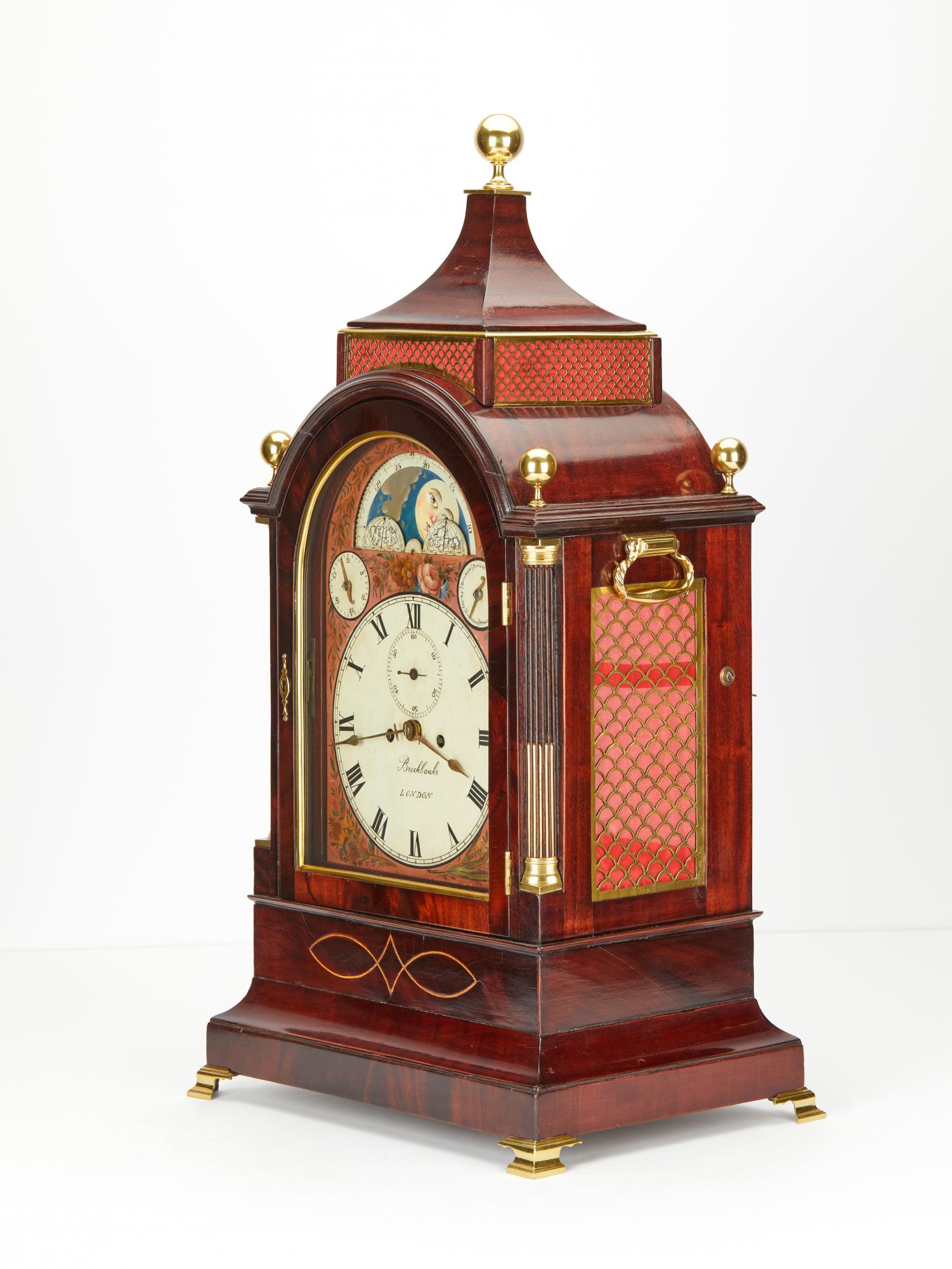 A good English mahogany bracket clock with a very nice multi color decorated painted dial. Charming Moon phase. Date numbers of the month. Special hand for indicating the days of the week.
The lovely Floral Mahogany case with pagoda top nice bronze