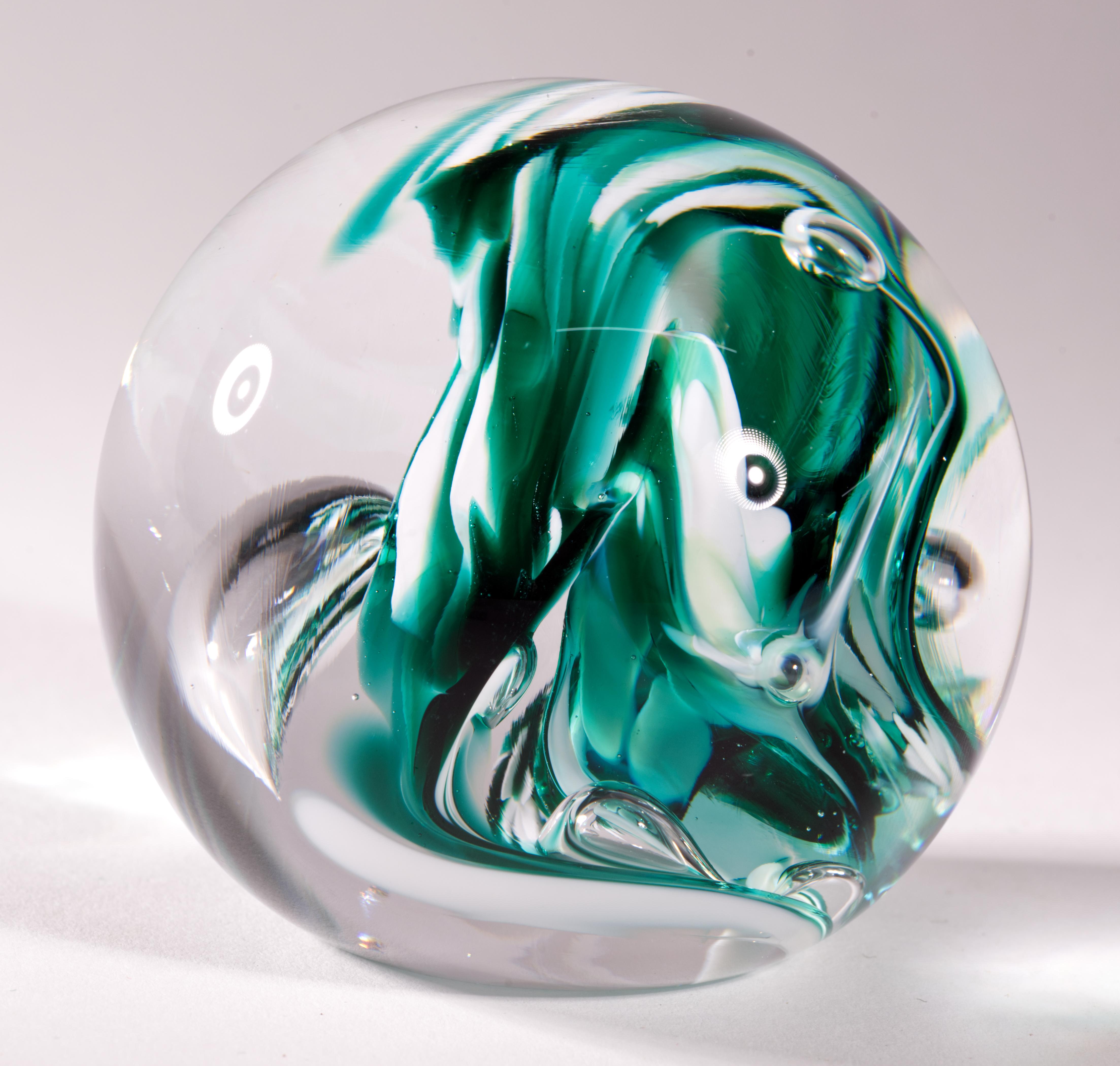  Der auffällige Briefbeschwerer hat ein abstraktes grünes und weißes Glasdesign, das in Klarglas eingeschlossen ist. Kontrollierte Blasen, die zwischen den frei fließenden farbigen Glasstrudeln verteilt sind, lenken das Auge und verleihen der