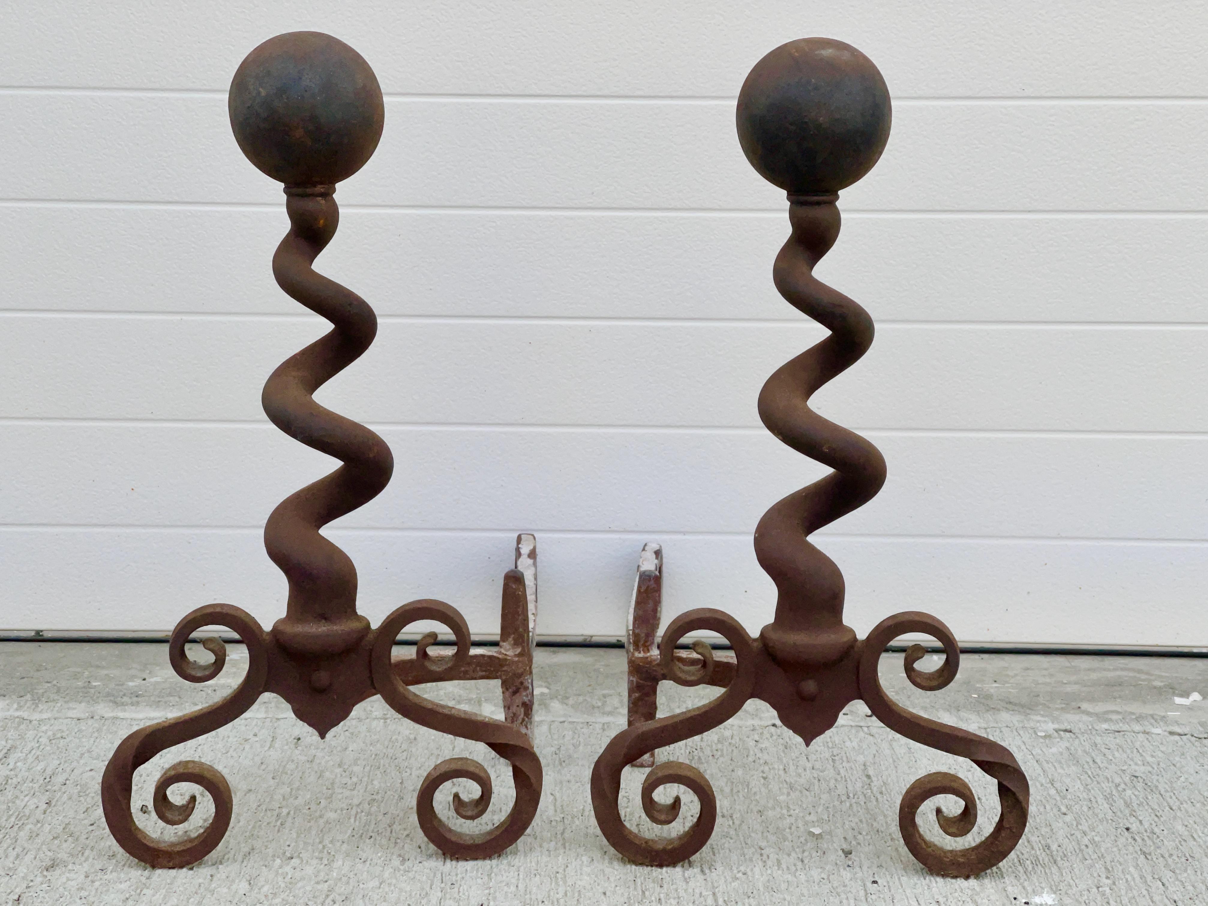 Bradley & Hubbard of Meridien, CT late 19th century pair of cast iron fireplace andirons with rounded sphere cannonball top surmounting a twisted corkscrew spiral shaft supported on scrolled legs and firedogs. 
Marked on back 