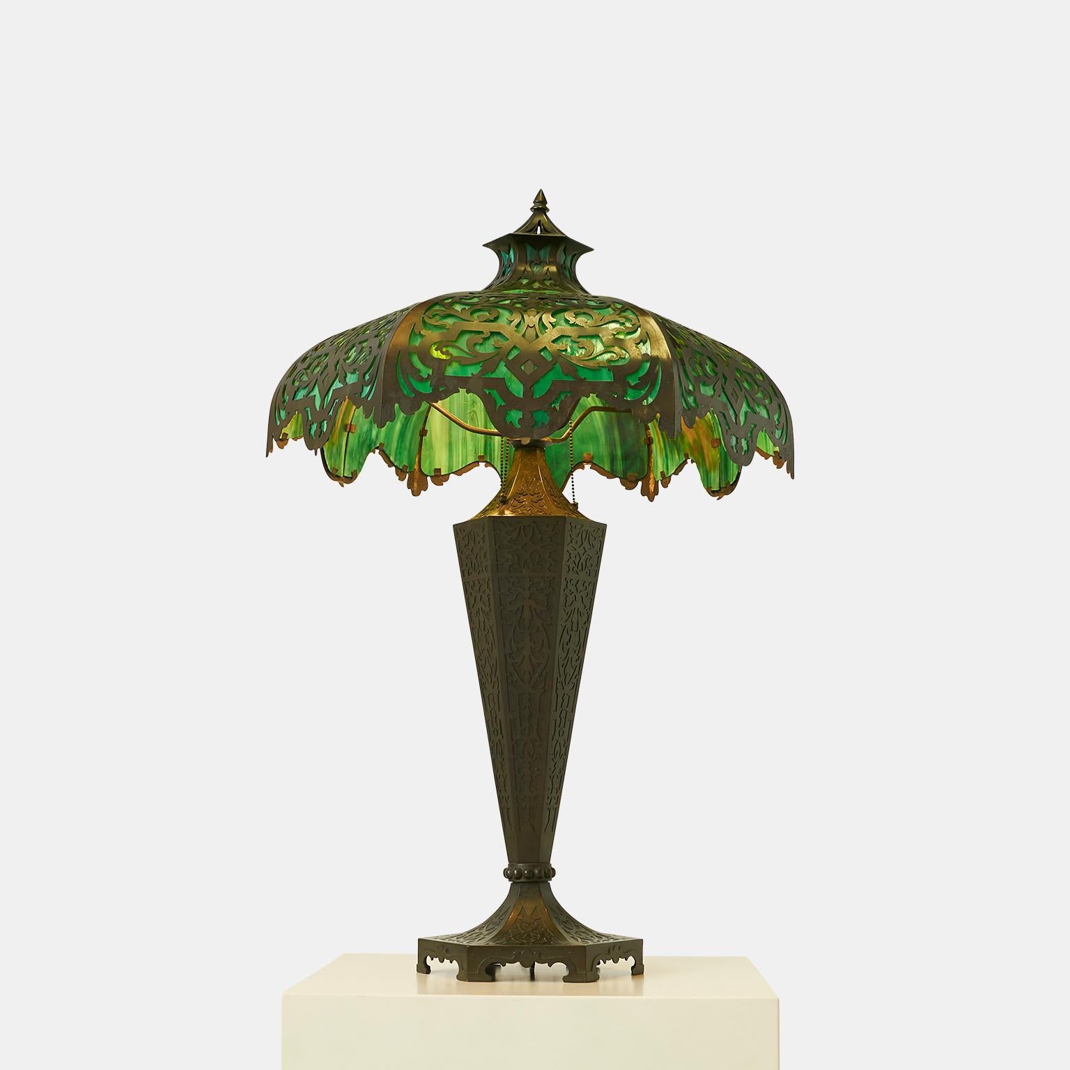 Bradley & Hubbard attributed table lamp
A large octagonal paneled table lamp with green slag glass shade, #T9365 on base, #18 872 Meriden, Connecticut. Base is made in bronze patinated metal and applied stamped tags. Three sockets with individual