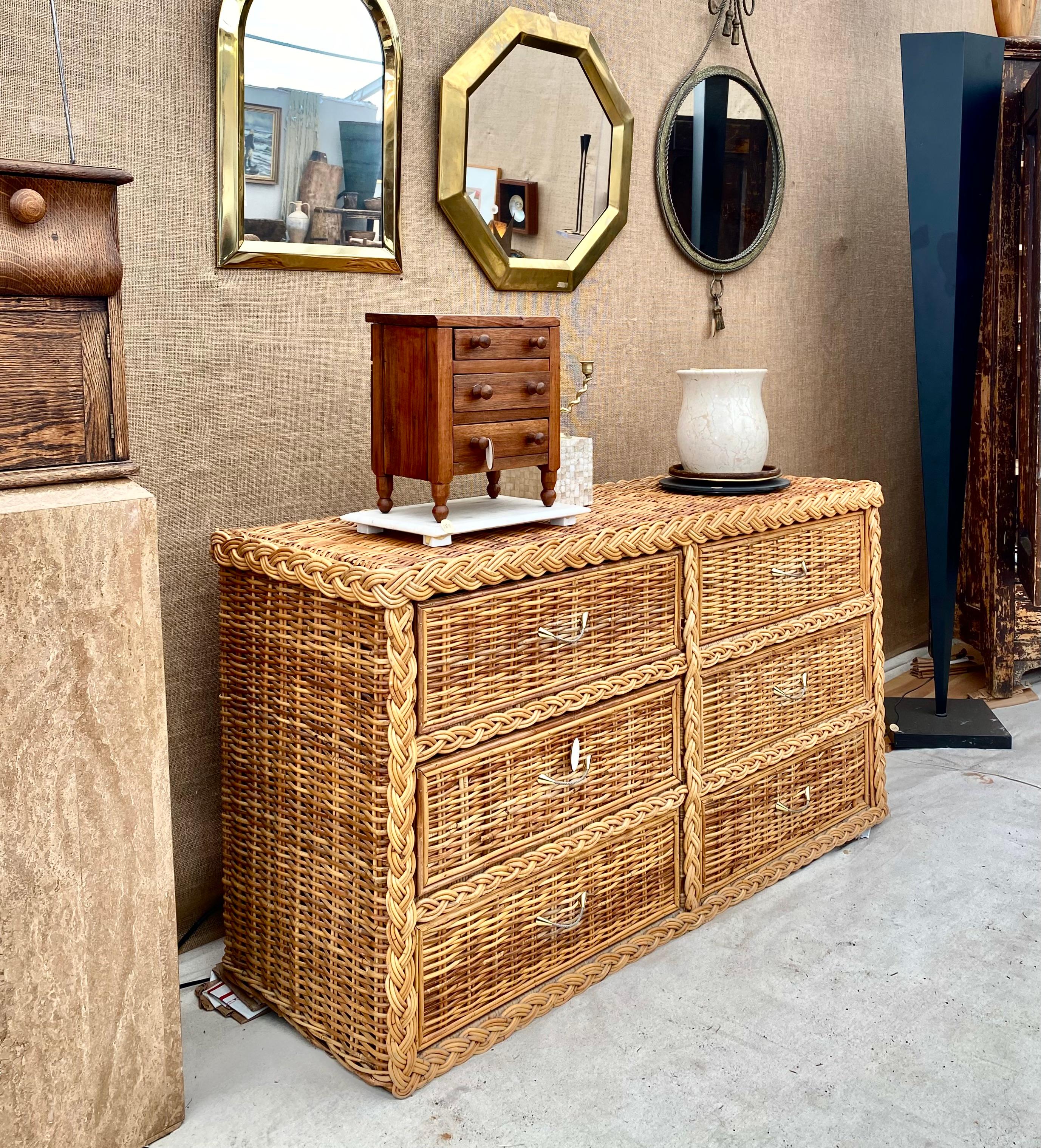 Charming woven rattan 6 drawer dresser with braided detailing and a finished back. 

Great piece that blends American chic, while referencing a British Campaign style, in natural textures and materials that surround a sturdy wood frame. Really