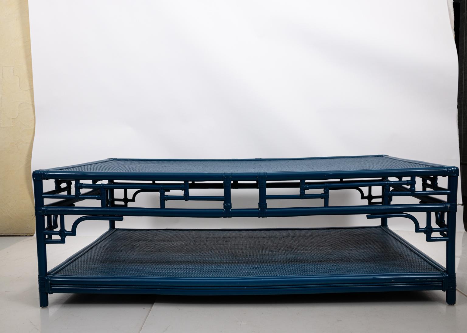 Blue painted, two tier braided Rattan and faux bamboo coffee in the Mid-Century Modern style, circa 1950s. Please note of wear consistent with age including minor wear and paint loss to the Rattan. Made in the United States.