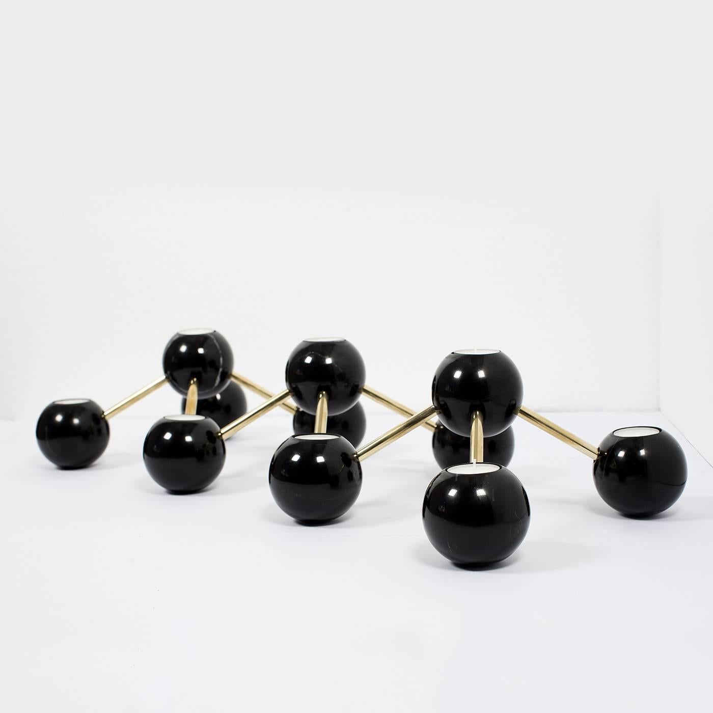 Modern and Minimalist, this candelabra will make an elegant statement on a console, shelf, or mantlepiece. Its 11 spheres in black Marquina marble are connected to each other with brass elements that have a natural polish. This striking piece of