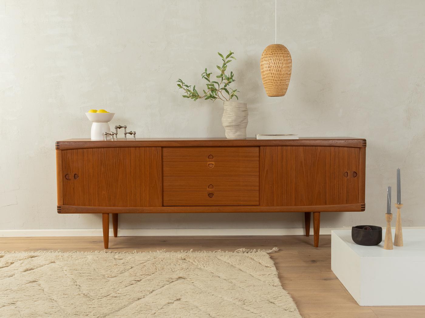 Classic sideboard from the 1960s. High quality corpus in teak veneer with two sliding doors, four drawers, two shelves and cigar shaped feet.

Quality Features:
    accomplished design: perfect proportions and visible attention to detail
    high