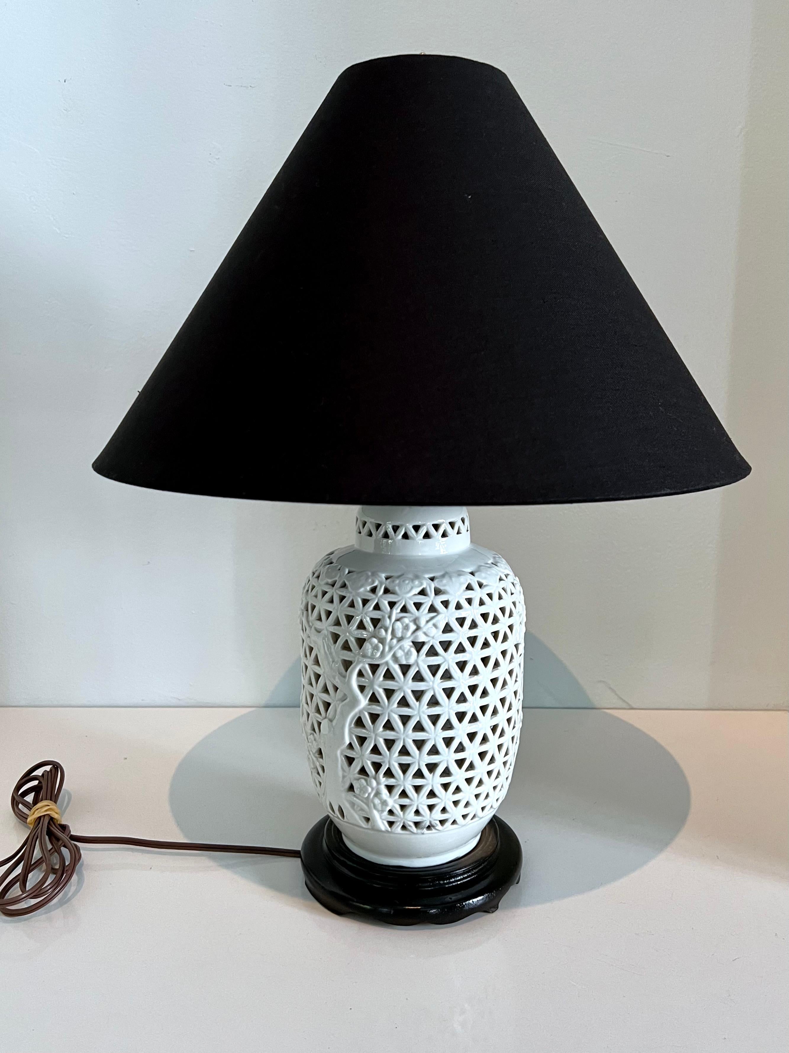 Gorgeous pierced blanc de chine lamp on black base with new custom black lampshade. A rotary on-off switch. Adds light and sophistication to any room, desk or side table

Measures: Base is 11