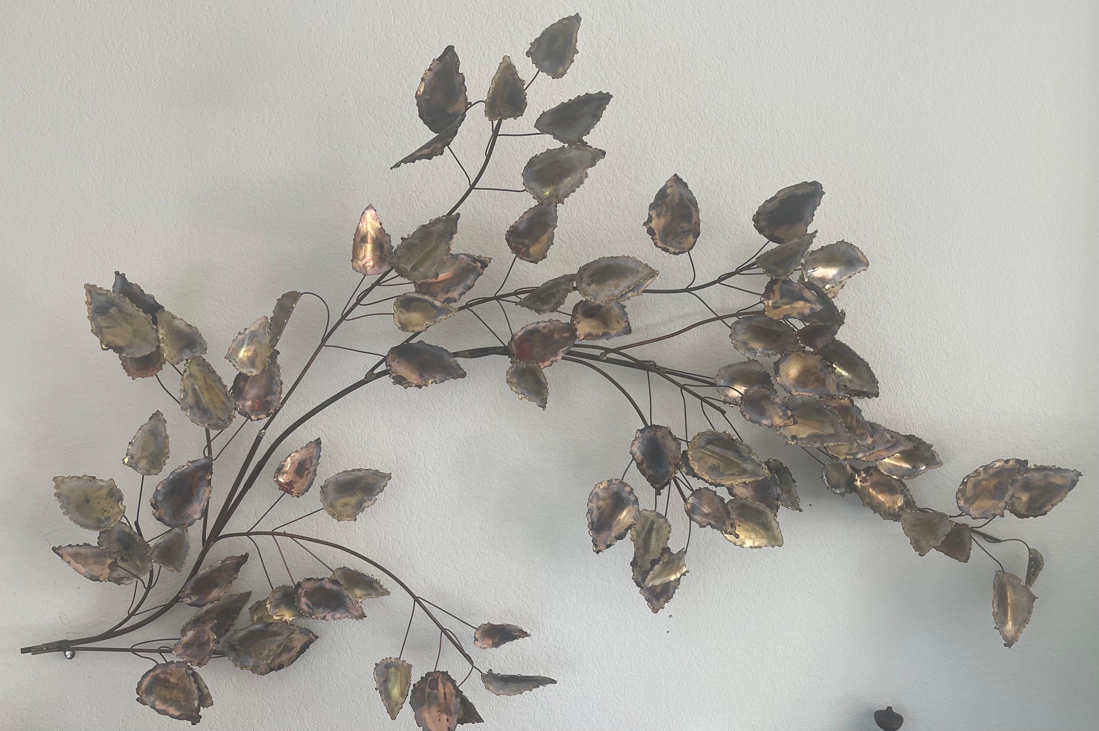 Unique and quite rare mixed metal wall sculpture by C. Jere for Artisan House, circa 1976. The piece, depicting a tree branch with hanging leaves, is in very good condition and has great color and craftsmanship. The sculpture displays patina