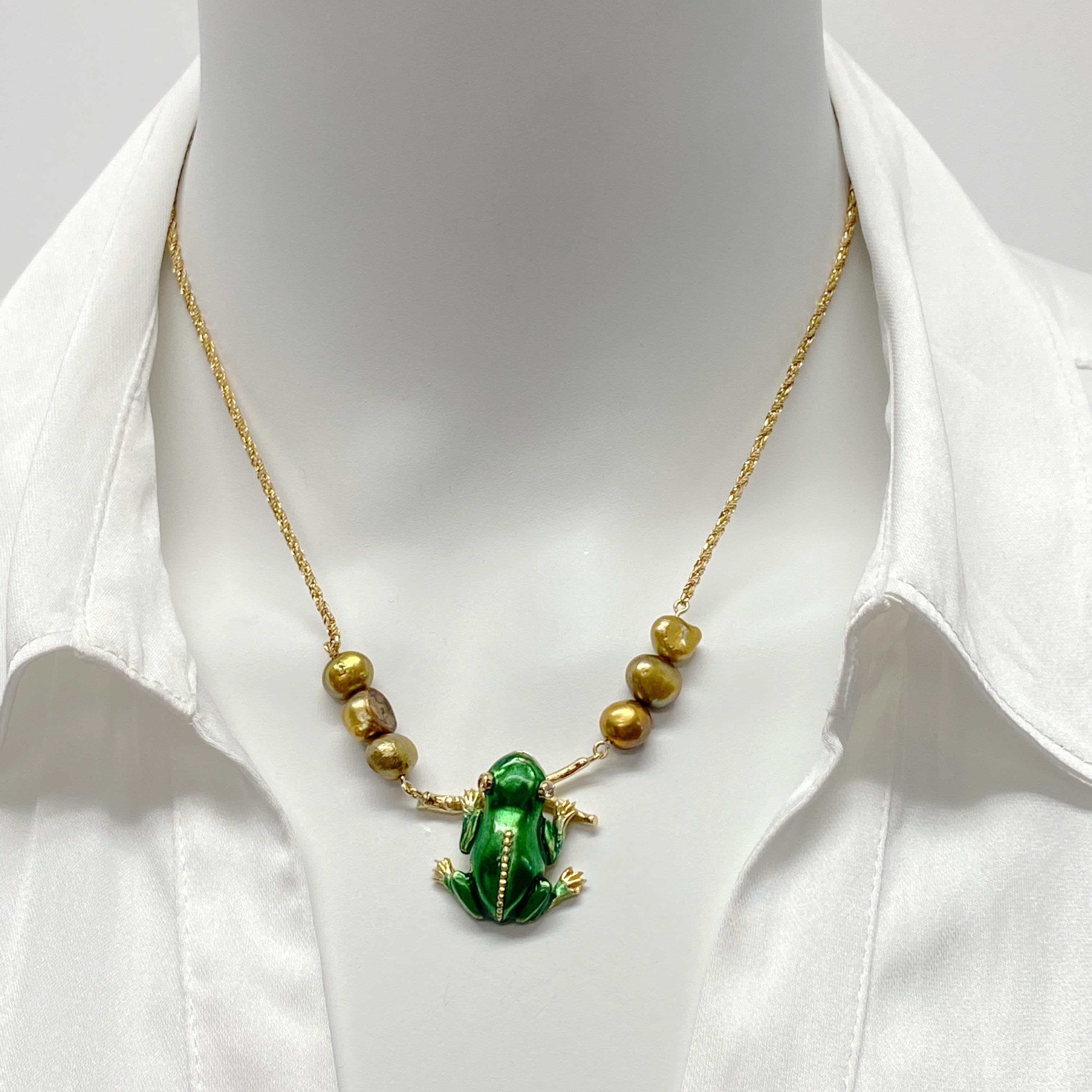 This one-of-a-kind necklace features an enamel frog pin, probably made in the early 1980s.  Eytan Brandes converted it to a necklace, stringing pearls and a chain from either end of Mister Frog's branch.  

The pearls are small dyed freshwater