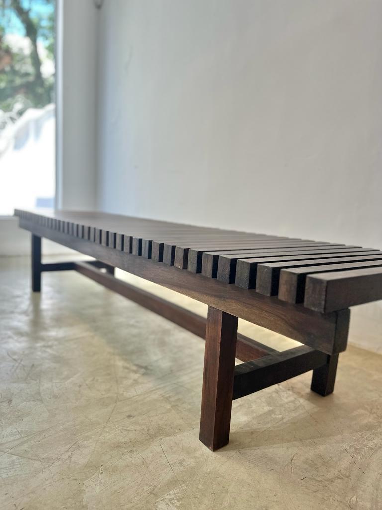Stylish slatted vintage bench from the early 1960's of Brazilian production, specifically Branco & Preto Gallery. In solid imbúia wood, it is a very versatile piece of furniture that can be used in a variety of ambients.