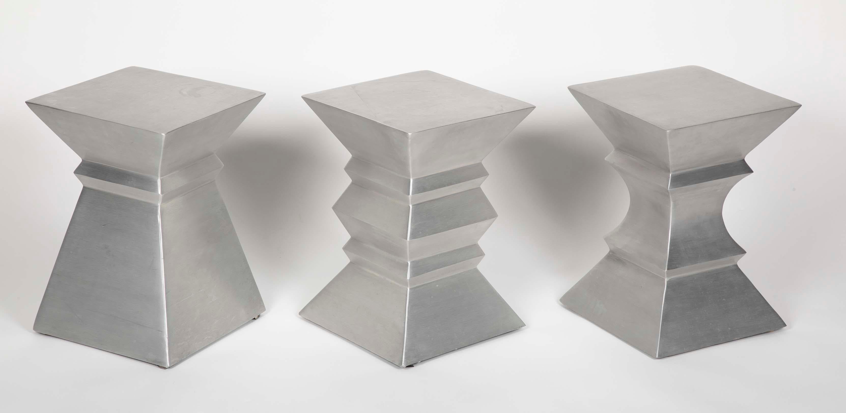 Set of three very stylish aluminum side tables in elegant geometric form. In the style of sculptor Constantin Brancusi. Will make unique side or drinks tables or pedestals. Or the three together as an alternative coffee table.