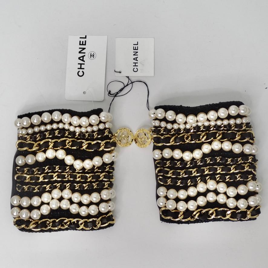 Do not miss out on these brand new Chanel fingerless gloves circa 2020! A true statement piece, these gloves feature a plethora of signature Chanel gold chains with interlocking black leather accompanied by rows of white pearls in varying sizes on