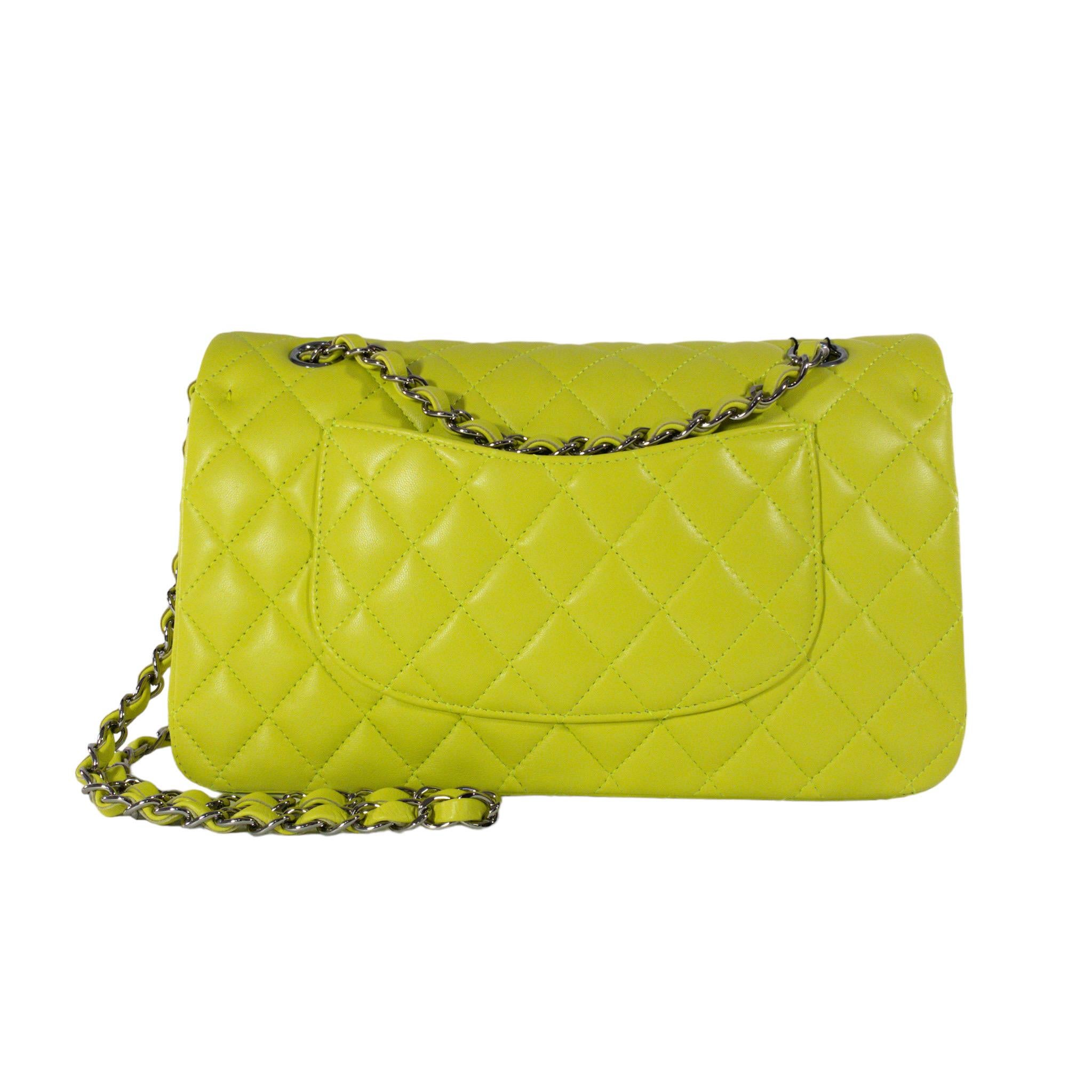 Consign of the Times presents this brand new authentic Chanel Medium Classic Flap in neon green/yellow leather. The bag has a flap closure with a Double C logo turn lock.  The interior is leather and includes one slip pocket and one zip pocket, it