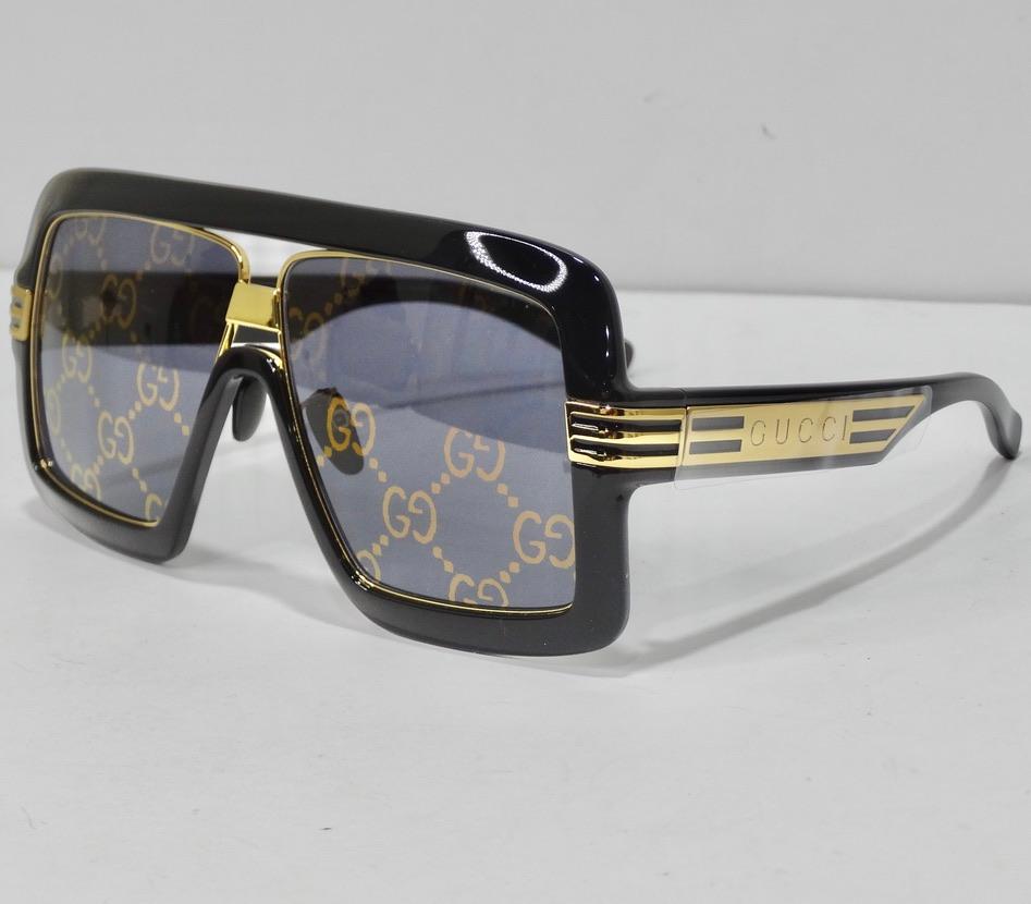 Les plus belles lunettes de soleil neuves de Gucci avec une lentille monogramme Gucci très amusante ! La monture carrée noire élégante est complétée par une quincaillerie dorée, des gravures du logo Gucci sur les deux côtés et des verres monogrammés