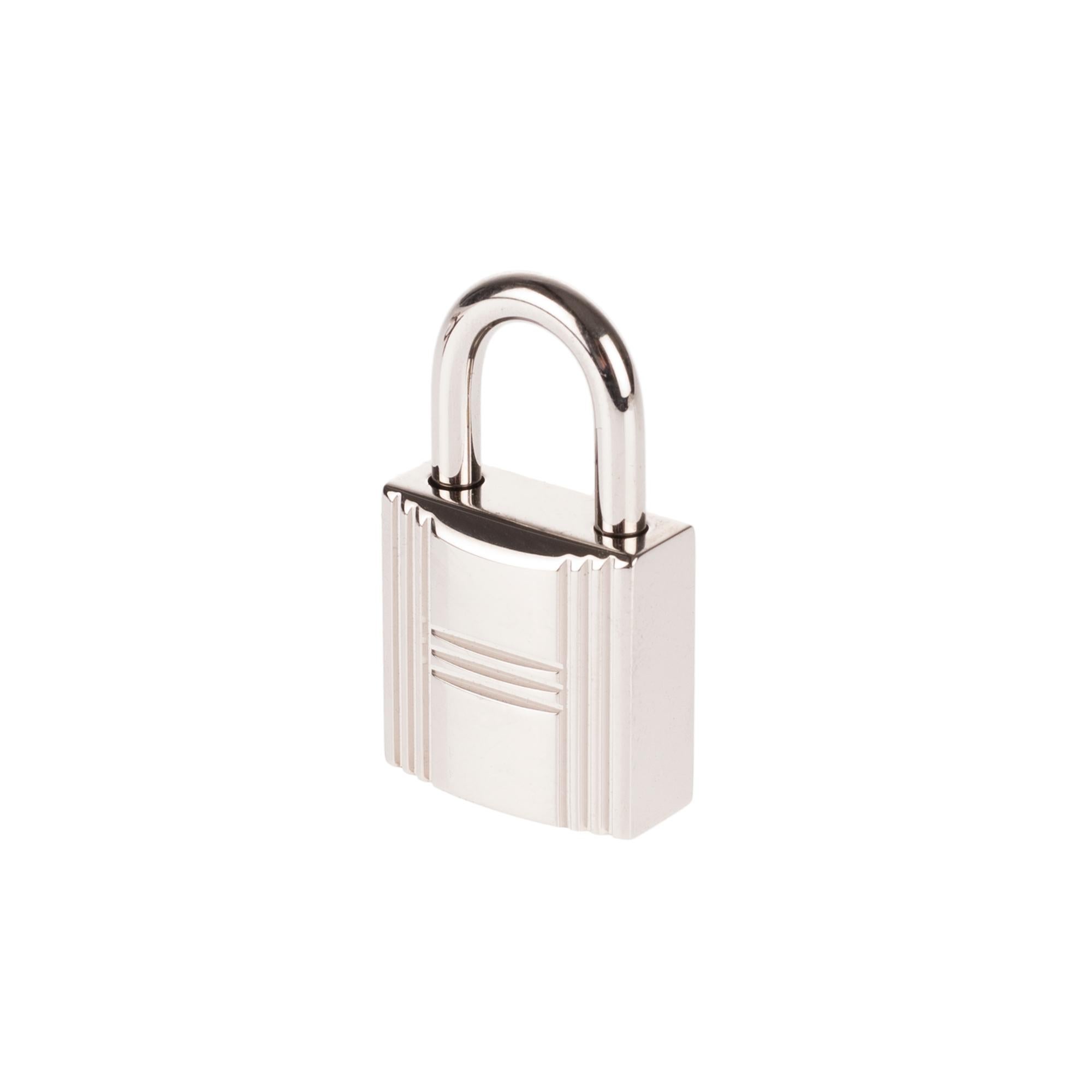 BRAND NEW Hermès Padlock in Palladium Silver for Birkin and Kelly.
Sold with its 2 keys (number 161) and dustbag.
Signature: Hermès.
Dimensions: 2 * 2 * 3,5 cm.
