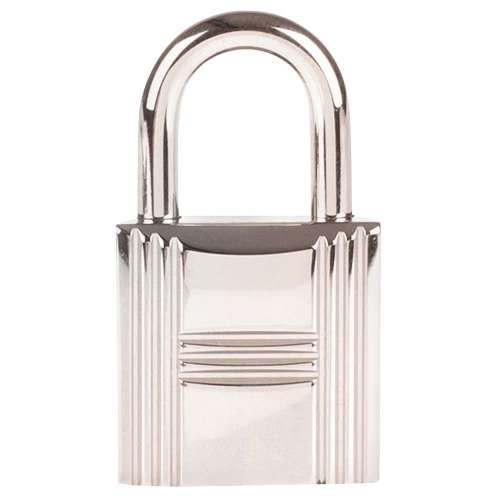 BRAND NEW Hermès Padlock in Palladium Silver for Birkin and Kelly.
Sold with its 2 keys and dustbag.
Signature: Hermès.
Dimensions: 2 * 2 * 3,5 cm.

Brand new- sold with dustbag
