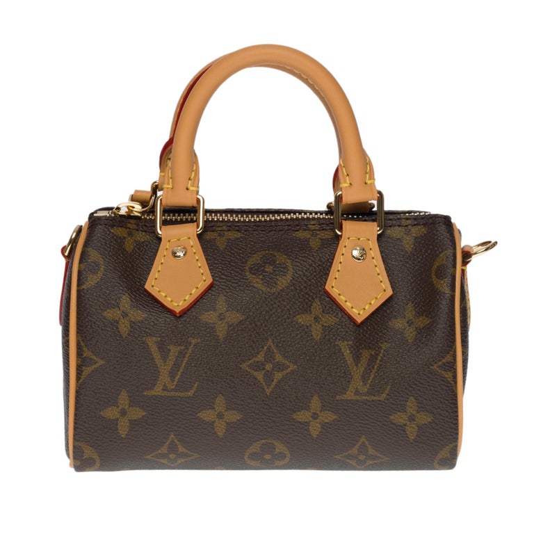 A miniature version of Louis Vuitton's iconic Speedy model, this Nano Speedy in Monogram canvas is ideal for carrying essentials. It is accented with natural distressed cowhide leather and gold metallic finishes. Two handles and an adjustable,