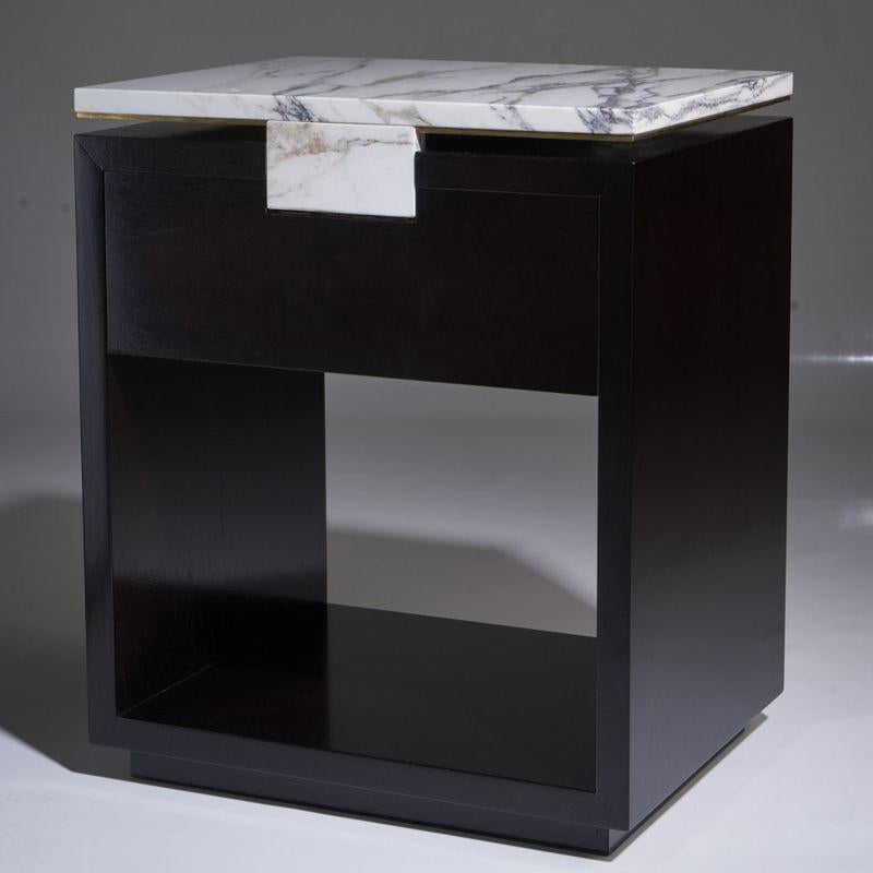 A rectangular bedside table in ebonized varnished walnut with drawer on self-centering sliding guides, central element covered in marble Breccia Medicea, top in marble Breccia Medicea with perimeter wire in brass. Designed by Atelier Avanzi.
 