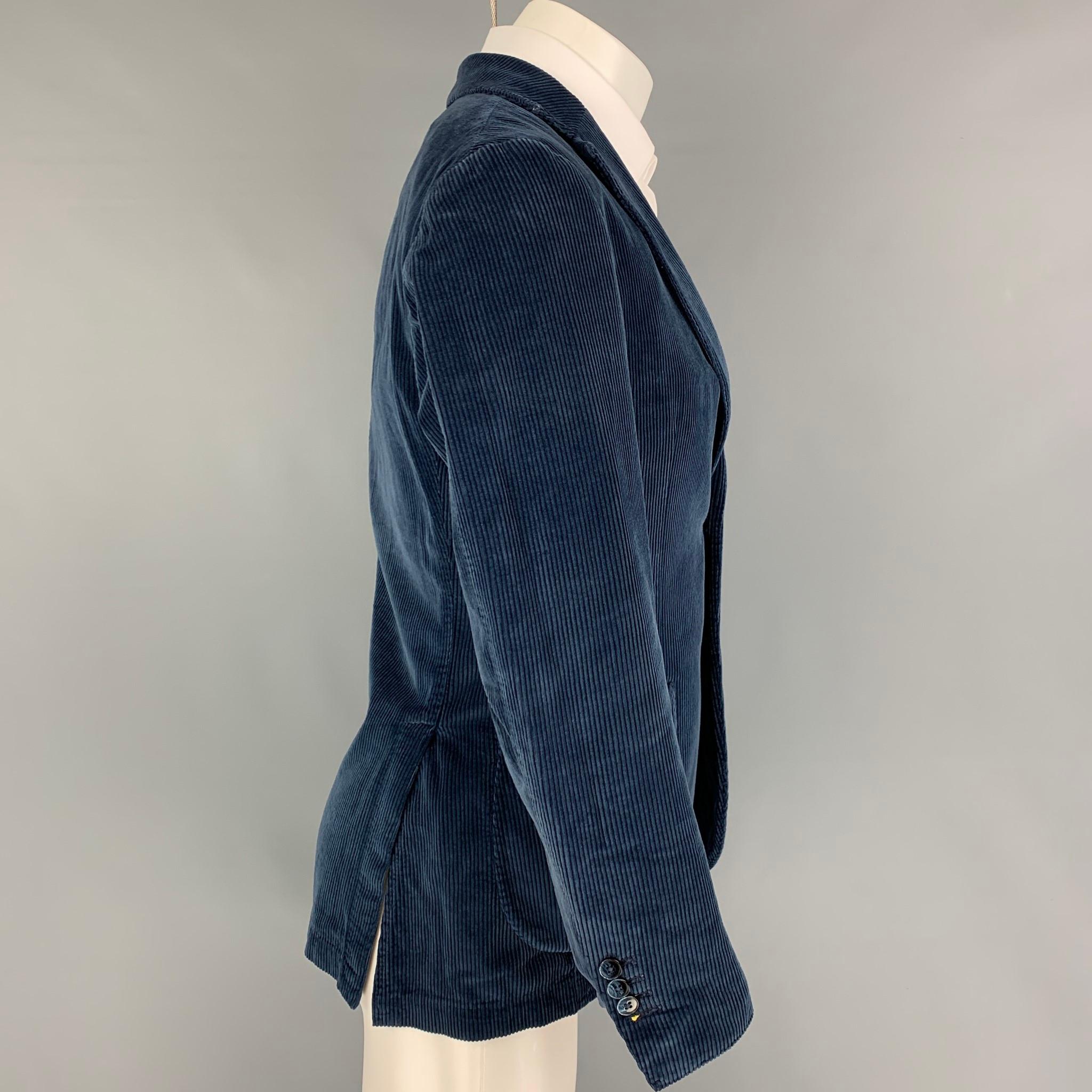 BRANDO sport coat comes in a blue corduroy cotton featuring a notch lapel, small flower pin, patch pockets, double back vent, and a double button closure. 

Very Good Pre-Owned Condition.
Marked: 46 R

Measurements:

Shoulder: 17 in.
Chest: 36