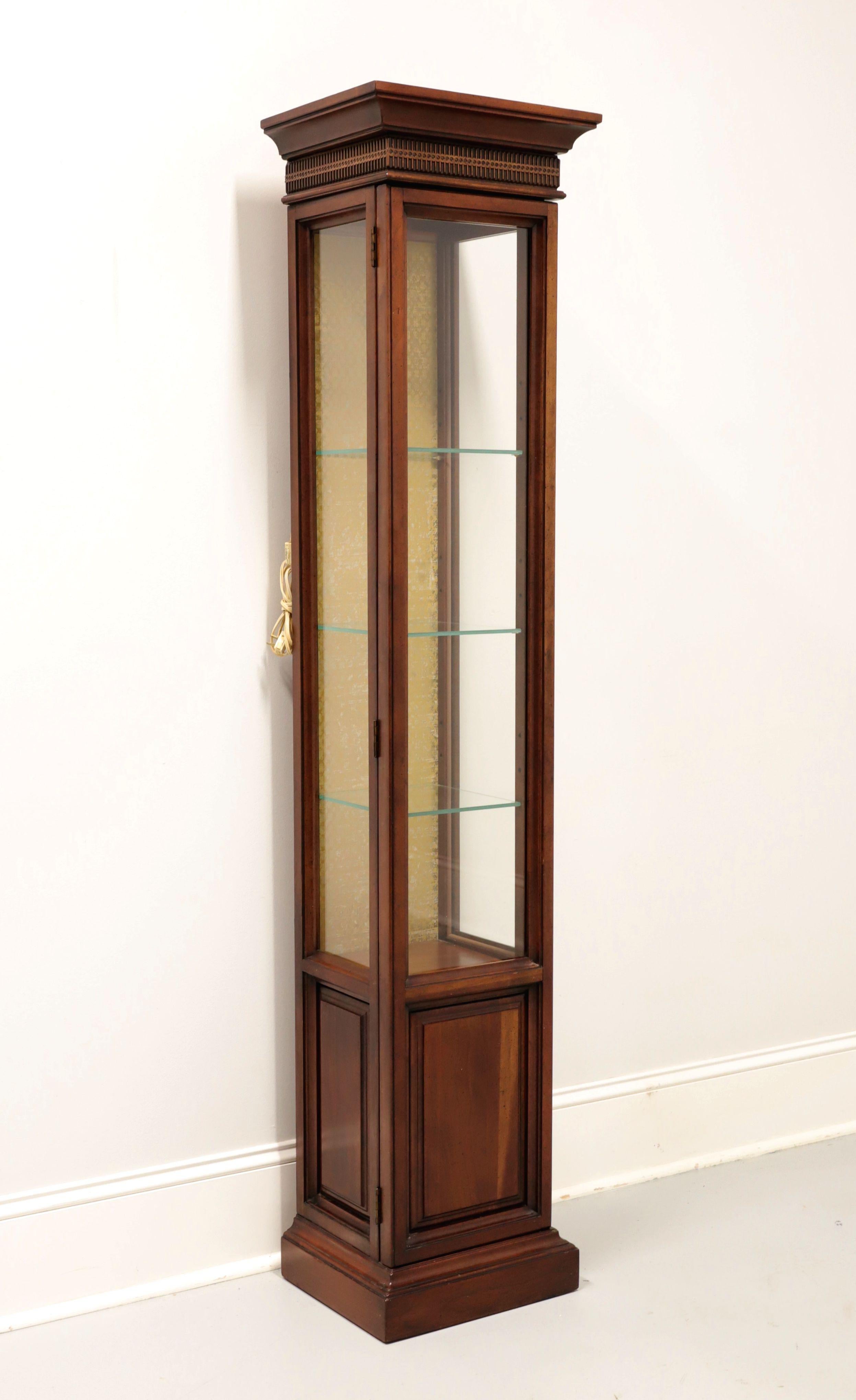 A Chippendale style diminutive curio display cabinet by Brandt. Cherry with slightly distressed finish, brass hinge hardware, crown moulding to top, fretwork to frieze, gold color distressed interior back panel, and a solid base. Upper cabinet has a
