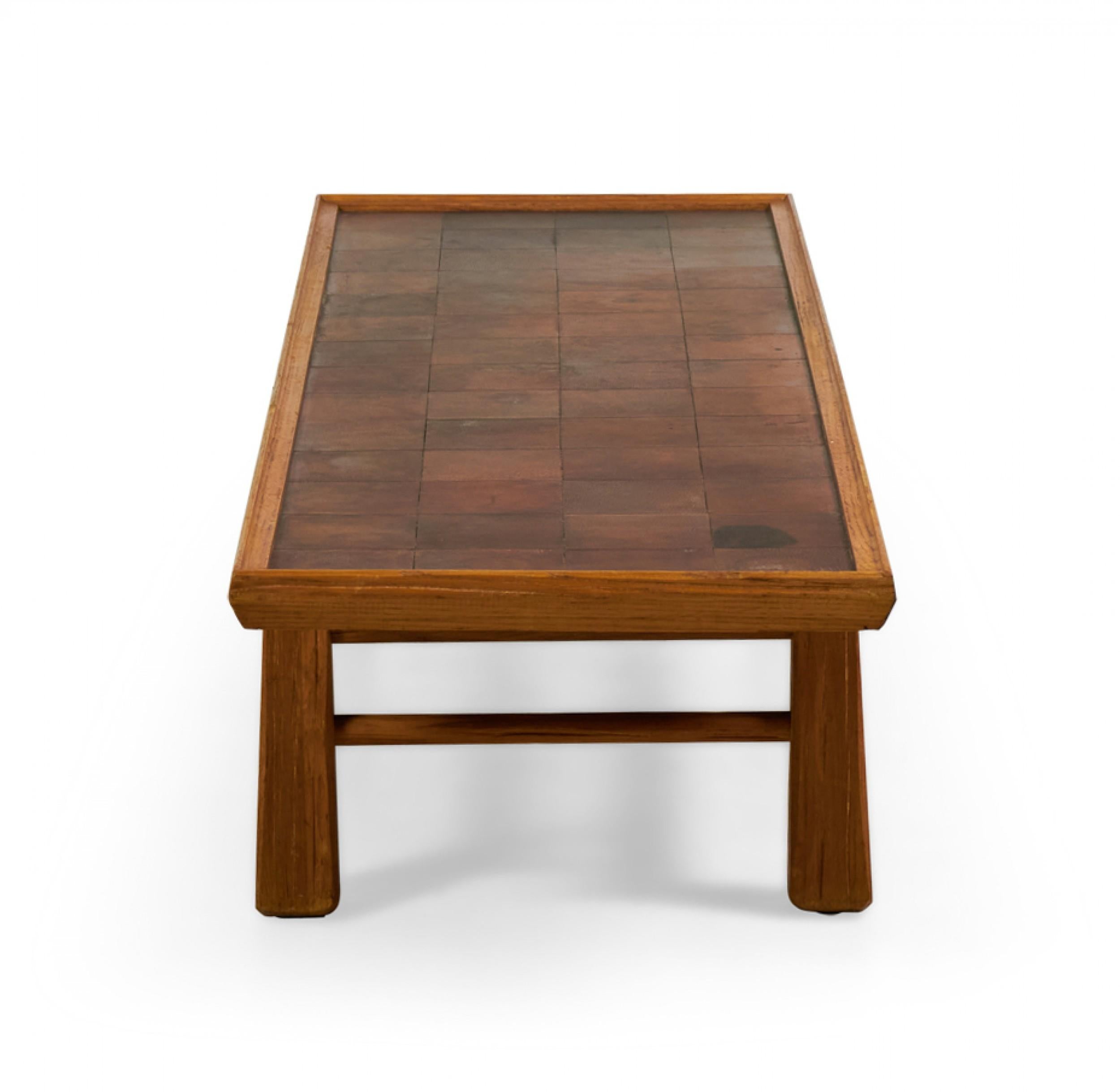 American Mid-Century Rustic (circa 1950) rectangular oak coffee table with a brown leather patchwork tabletop resting on four rustic legs with a stretcher base. (BRANDT RANCH, TEXAS)