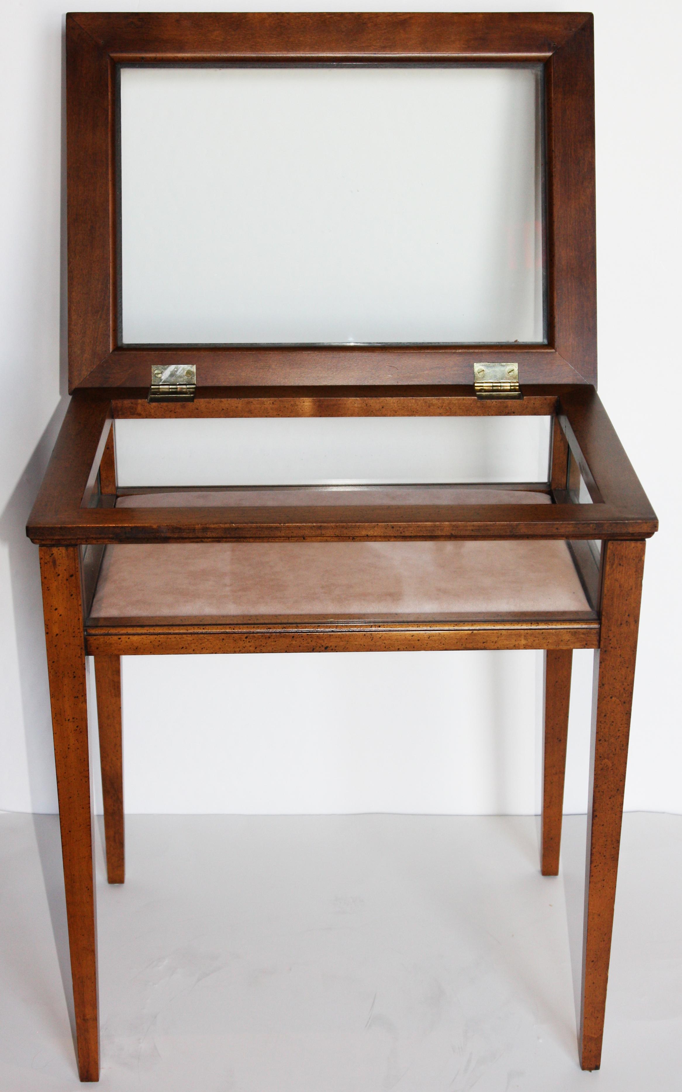 A beautifully made Brandt vitrine with hinged top and upholstered glass display case. Brandt makers tags are shown on the bottom of the piece.
