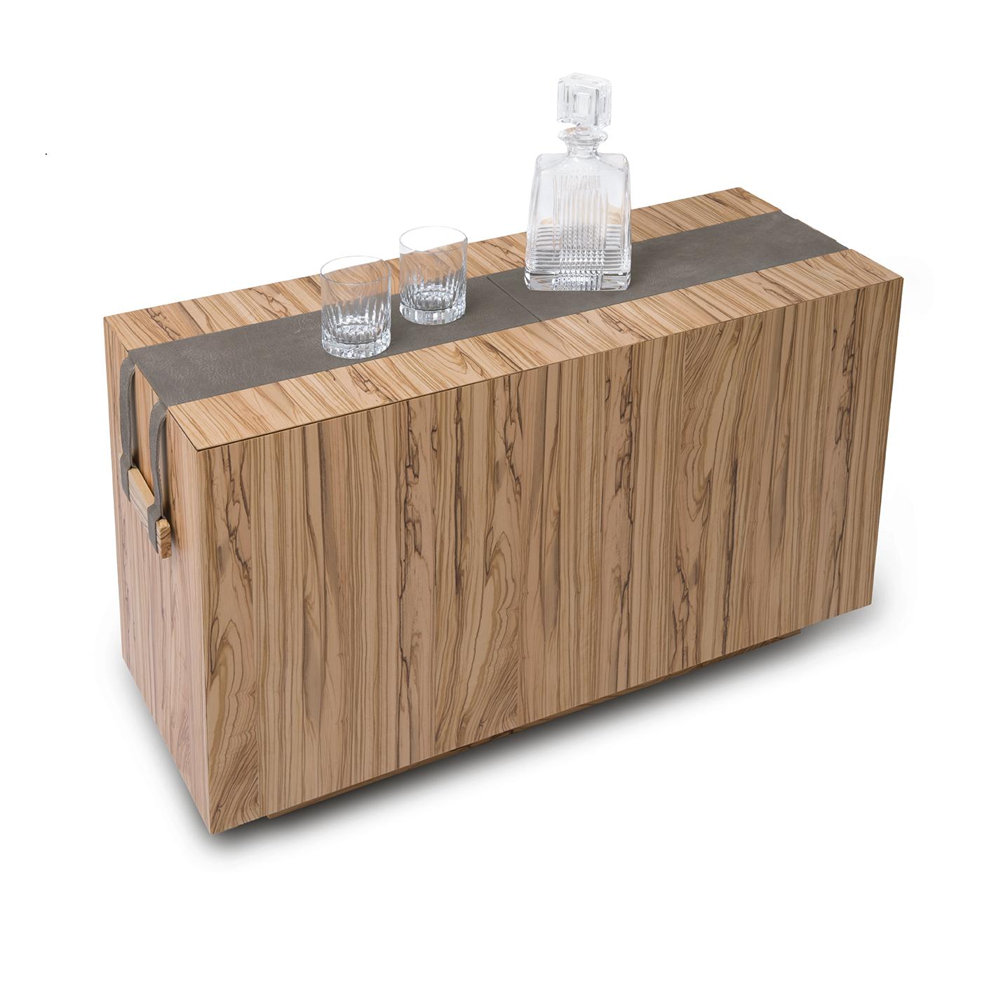 This unique, practical coffee table is perfect for any user who enjoys socializing, due to its compartment for bottles and glasses. It can also be used to organize and stow other objects, including magazines. Made from olive wood and genuine