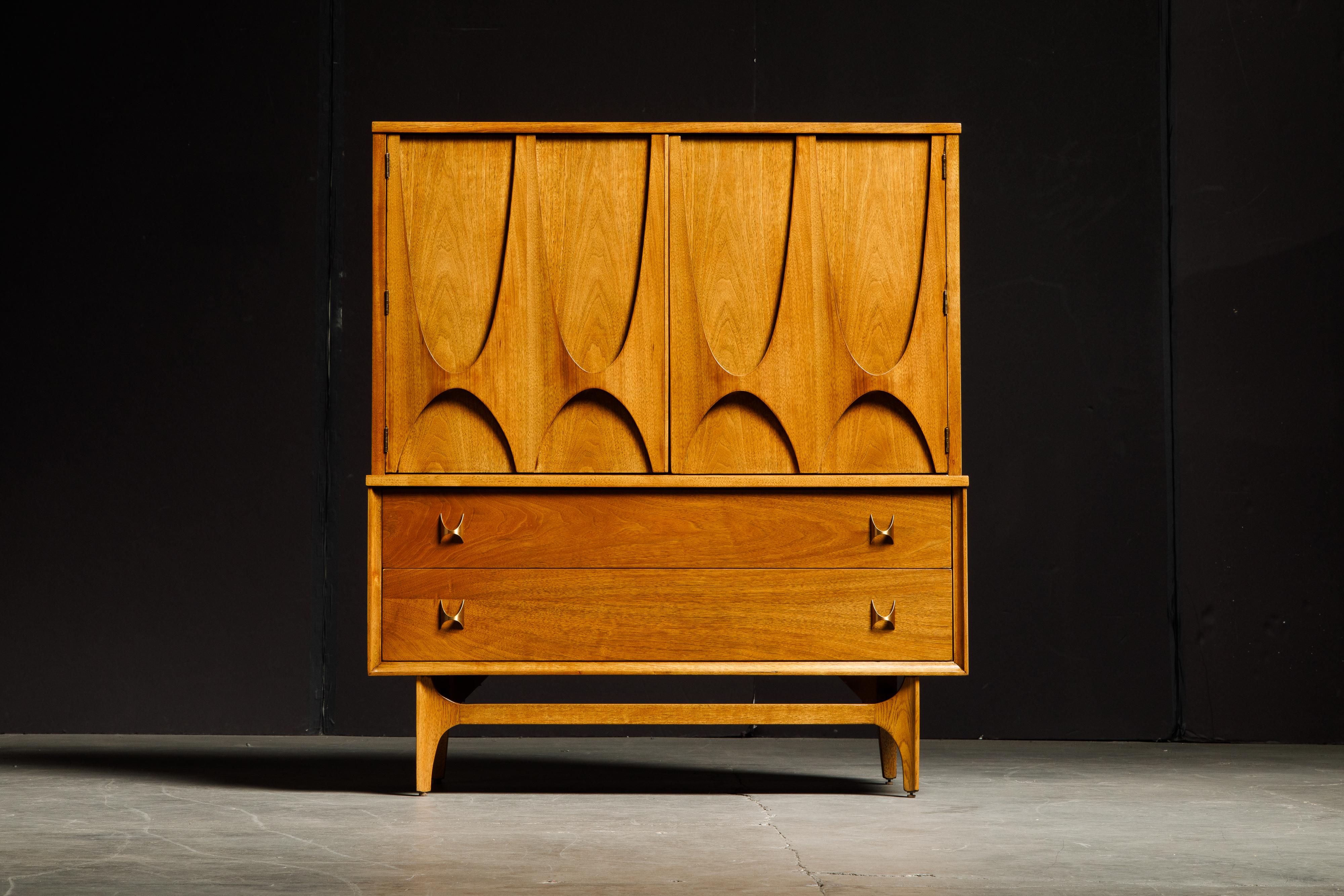 This gorgeous 'Brasilia' highboy dresser was just refinished and is such a gorgeous piece, and is signed with its original Brasilia stamp and date stamped on the backside. This beautiful gentleman's dresser, features the signature Brasilia sculpted