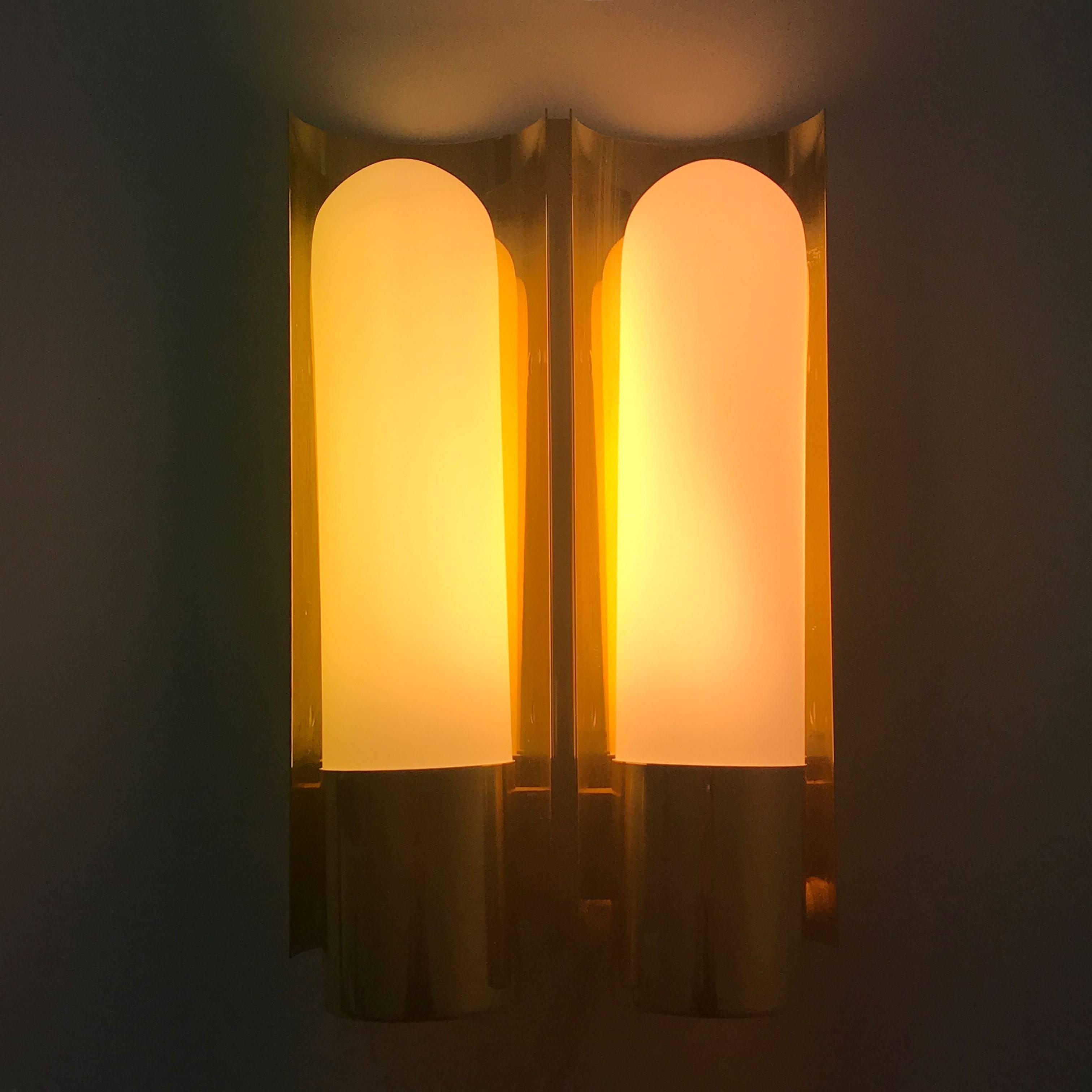 Elegant Mid Century Modern sconces or wall lamps. Designed and manufactured by Glashütte Limburg, Germany, 1980s.

Executed in brass and opaline glass, the lamp needs two TC 11W. 220 Volt. It works on 230 Volt. For use on 110 Volt, you need to