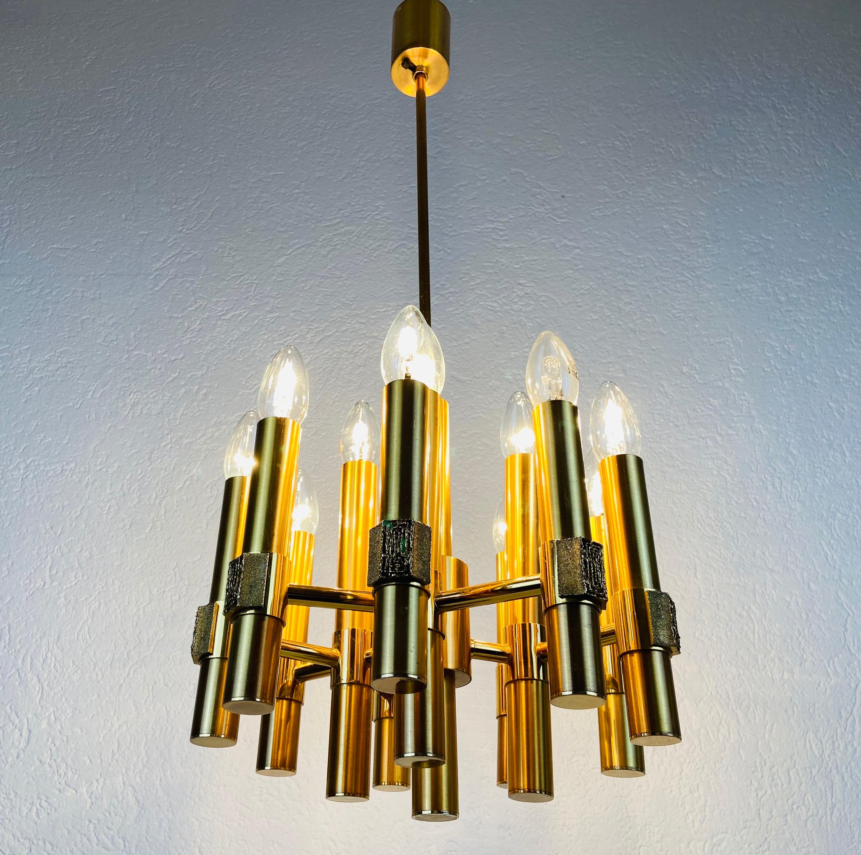An extraordinary chandelier made in Italy by Angelo Brotto in the 1960s. It is fascinating with its 12 amazing arms. The body is made of full brass and has a very elegant style. 

The light requires 12 E14 light bulbs. Works with both 120/220V. Good